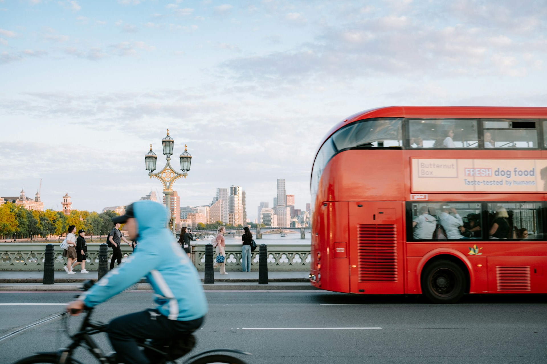 Cyclist passing a red London double-decker bus on Westminster Bridge