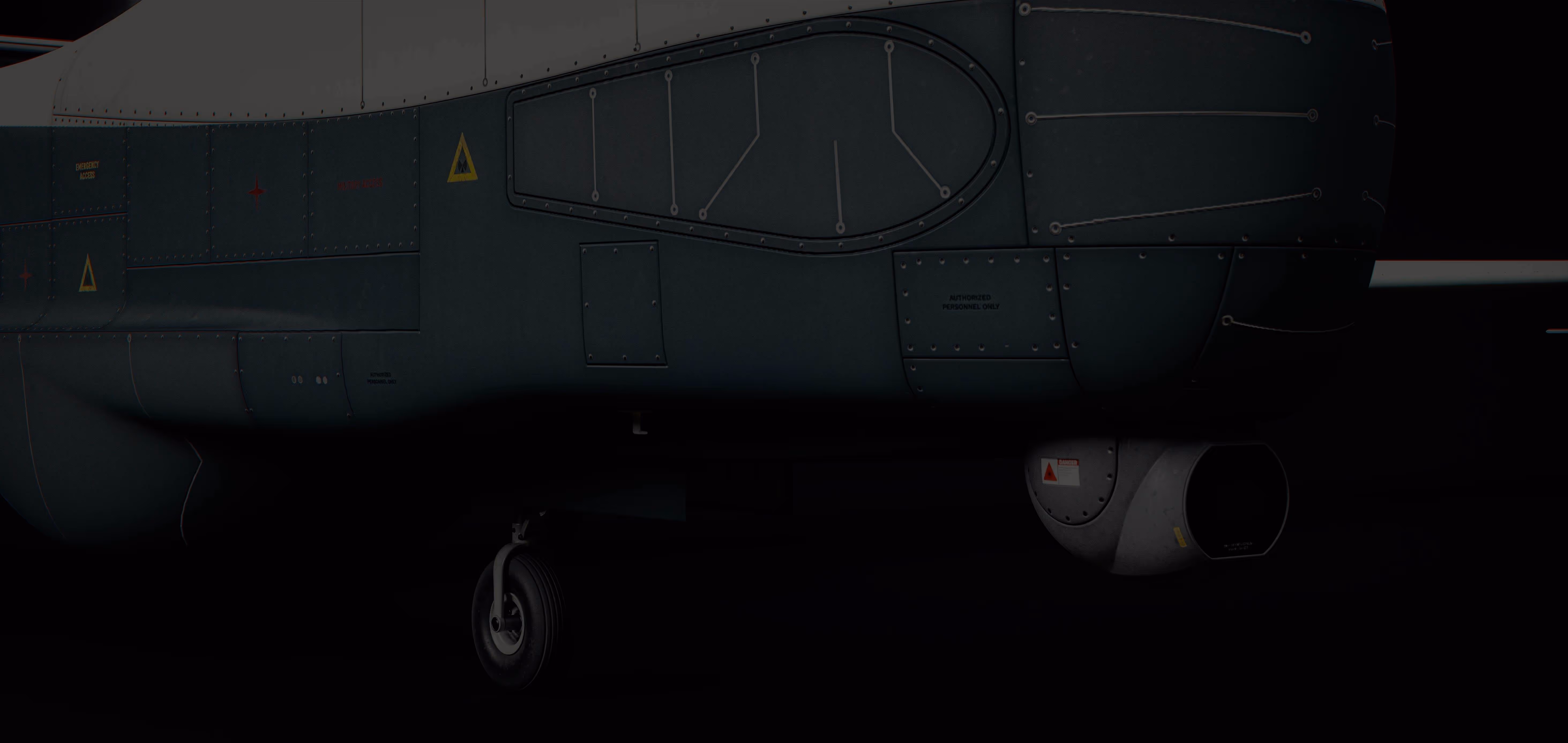 Close-up of a drone's dark green body showing detailed paneling, warning labels, and a wheel beneath the fuselage.