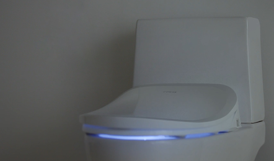 Modern Coway BA-42A bidet toilet with a blue LED light glowing underneath the seat.