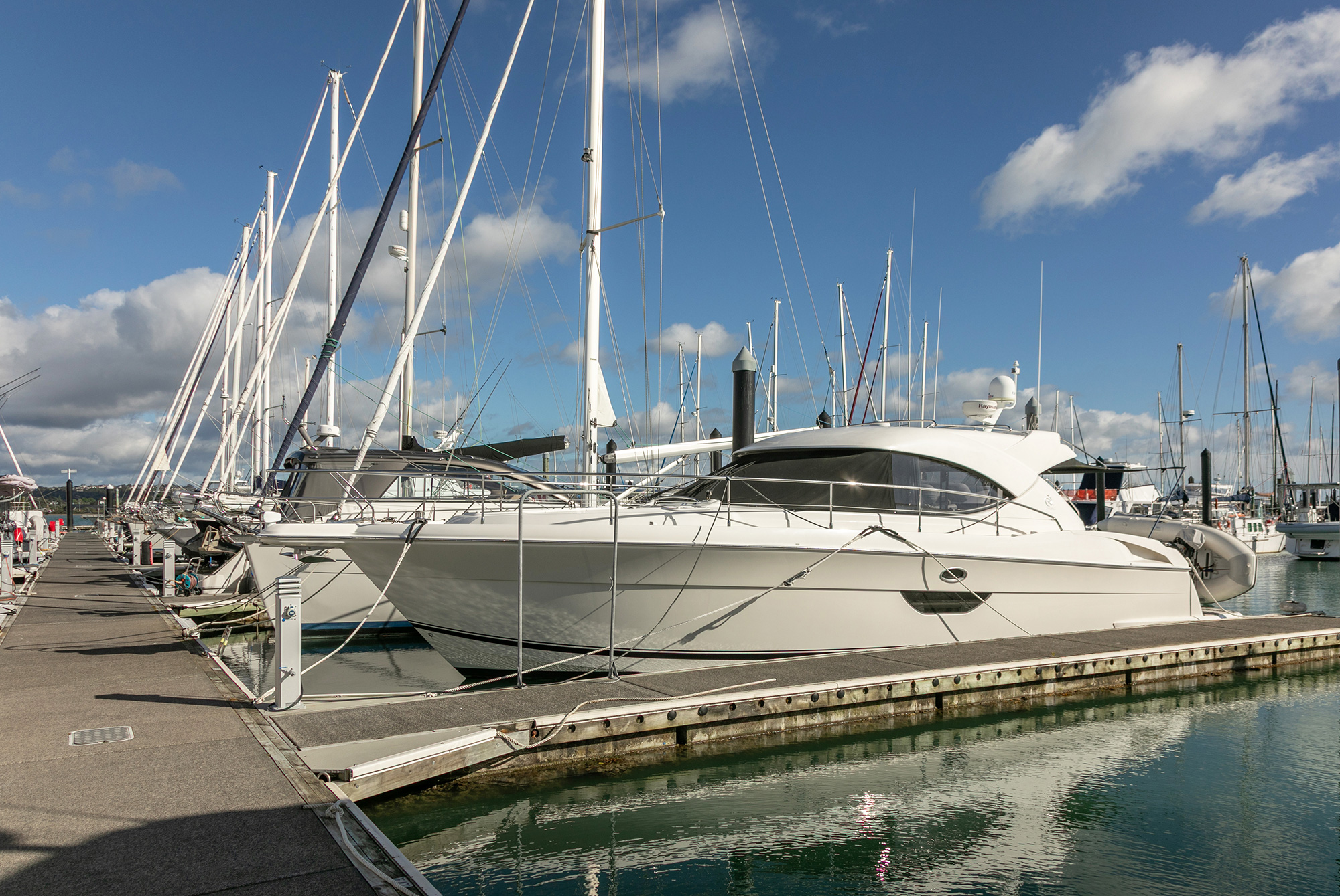Launches and yachts berthed along a pontoon at Bayswater Marina
