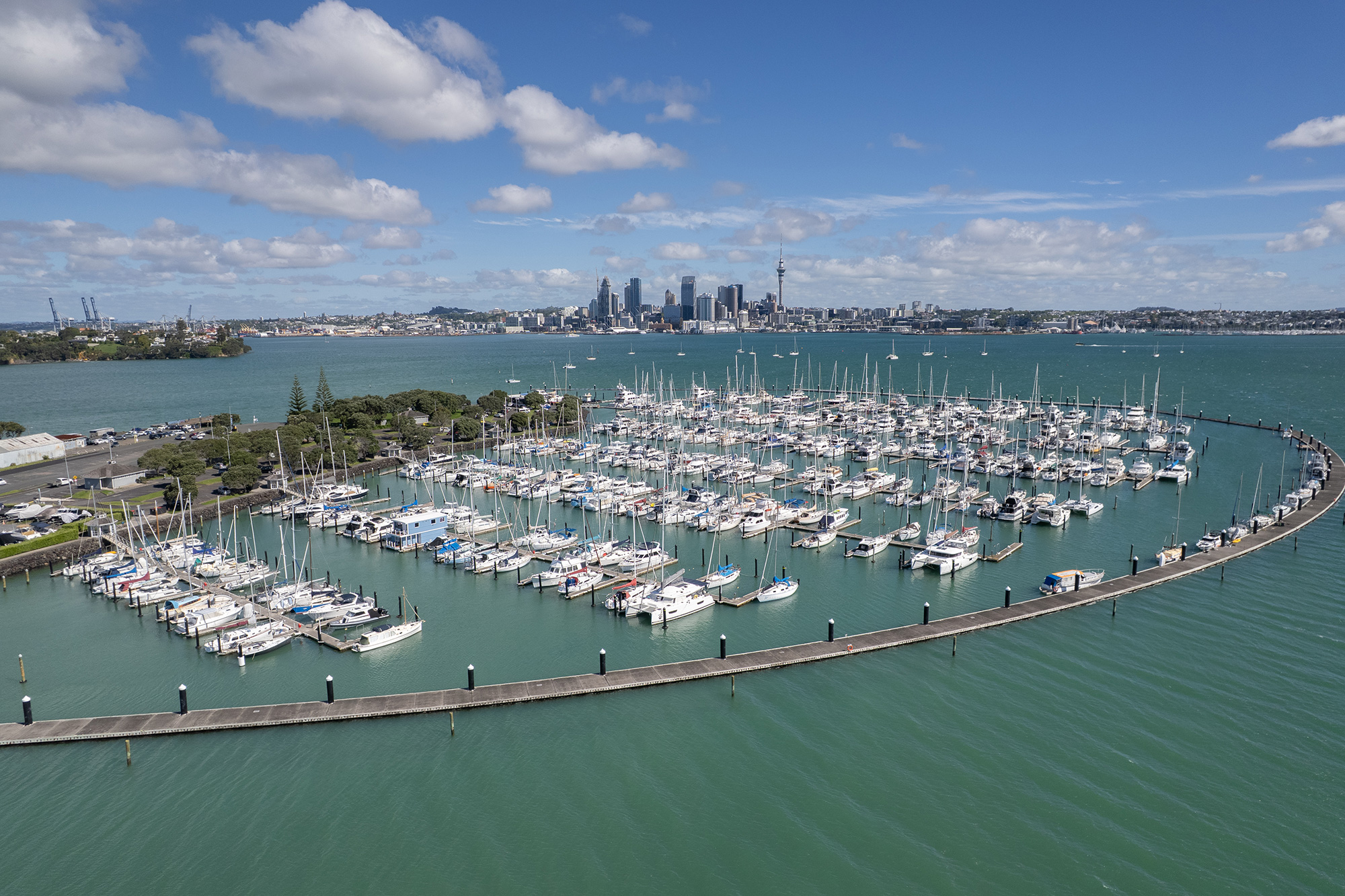 Aerial view of Bayswater Marina and its breakwater with the Auckland city skyline