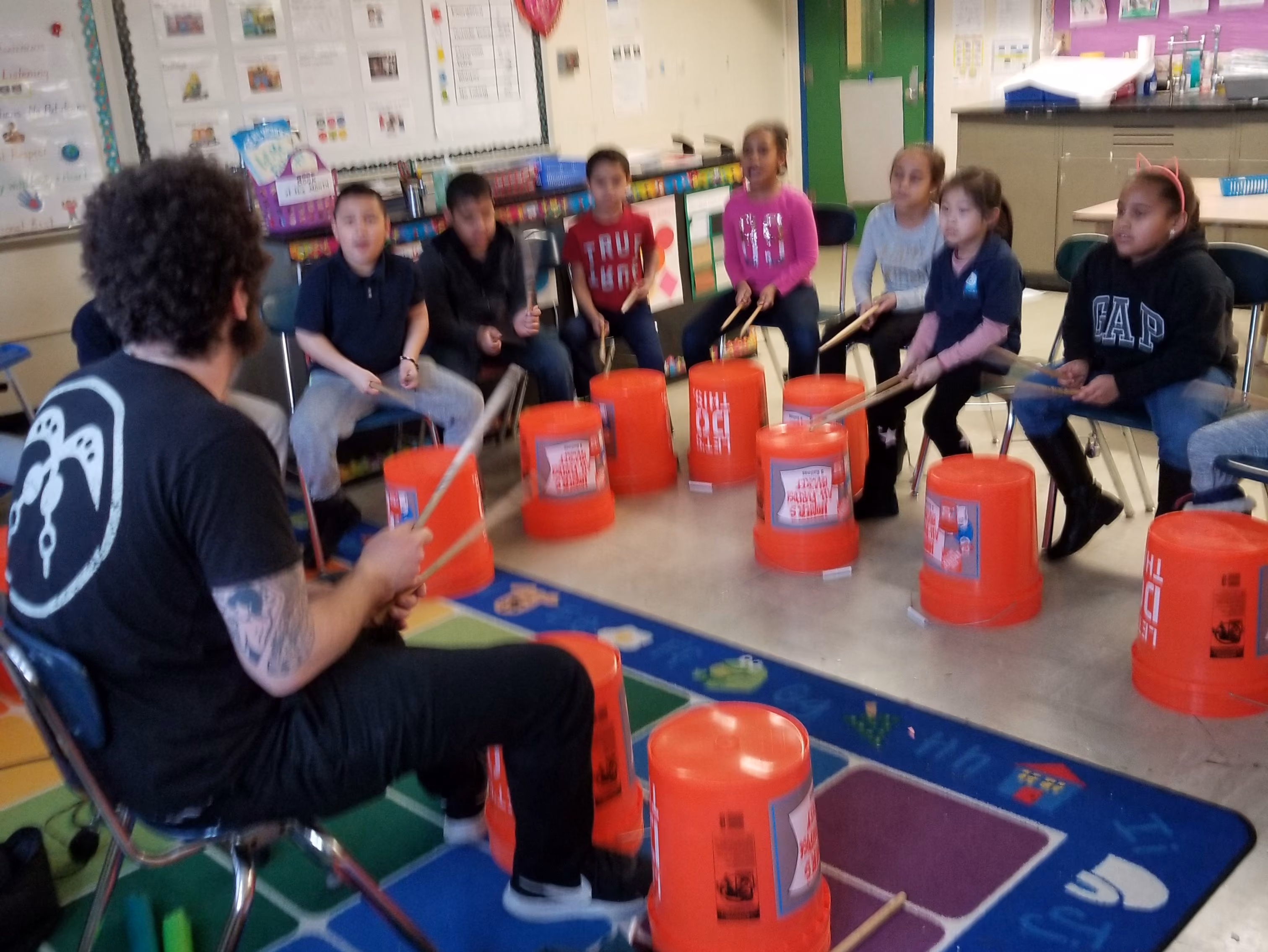 Students drumming on buckets in music class
