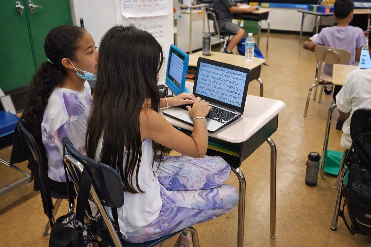 Students working on laptops in technology class