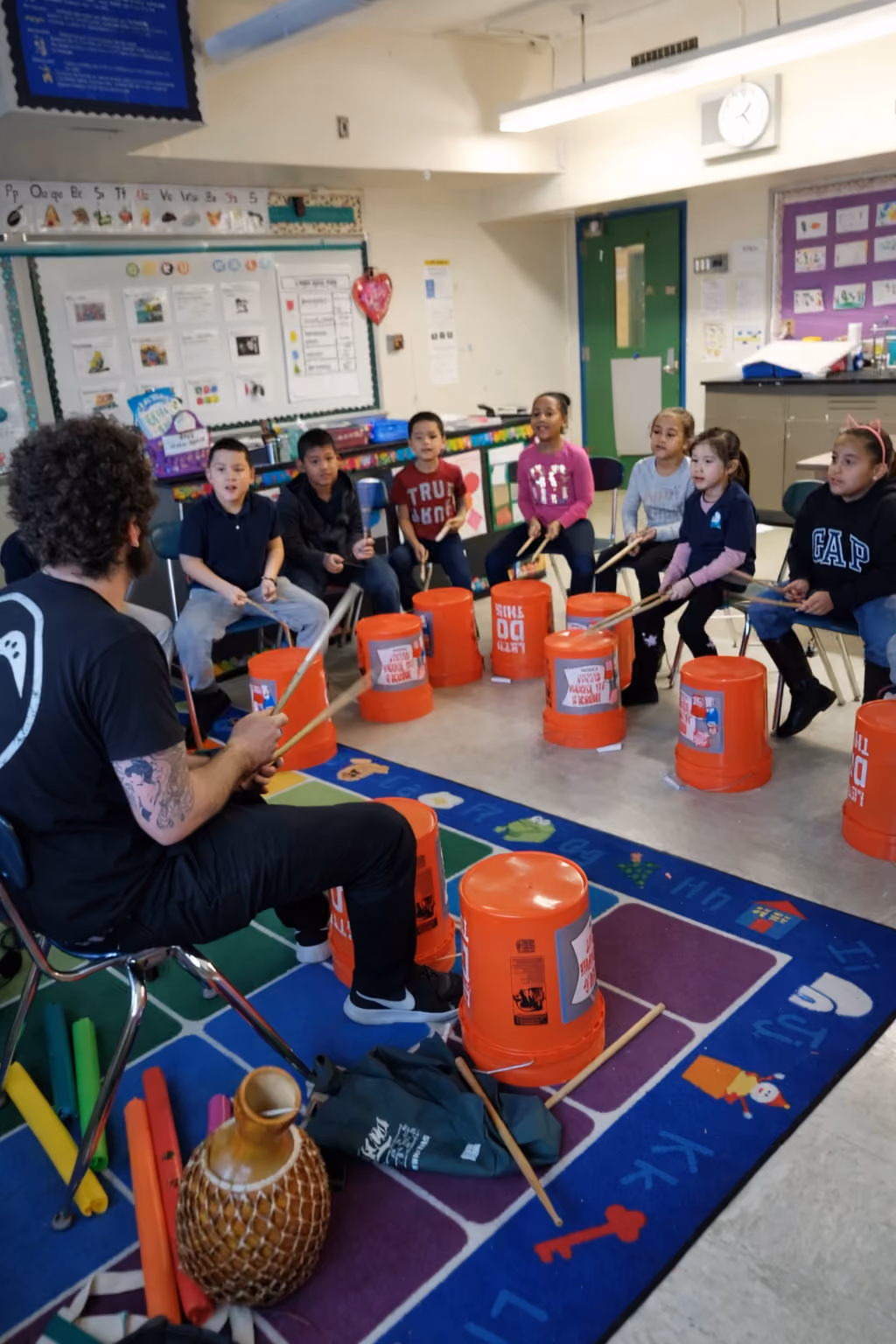 Students drumming on buckets in music class