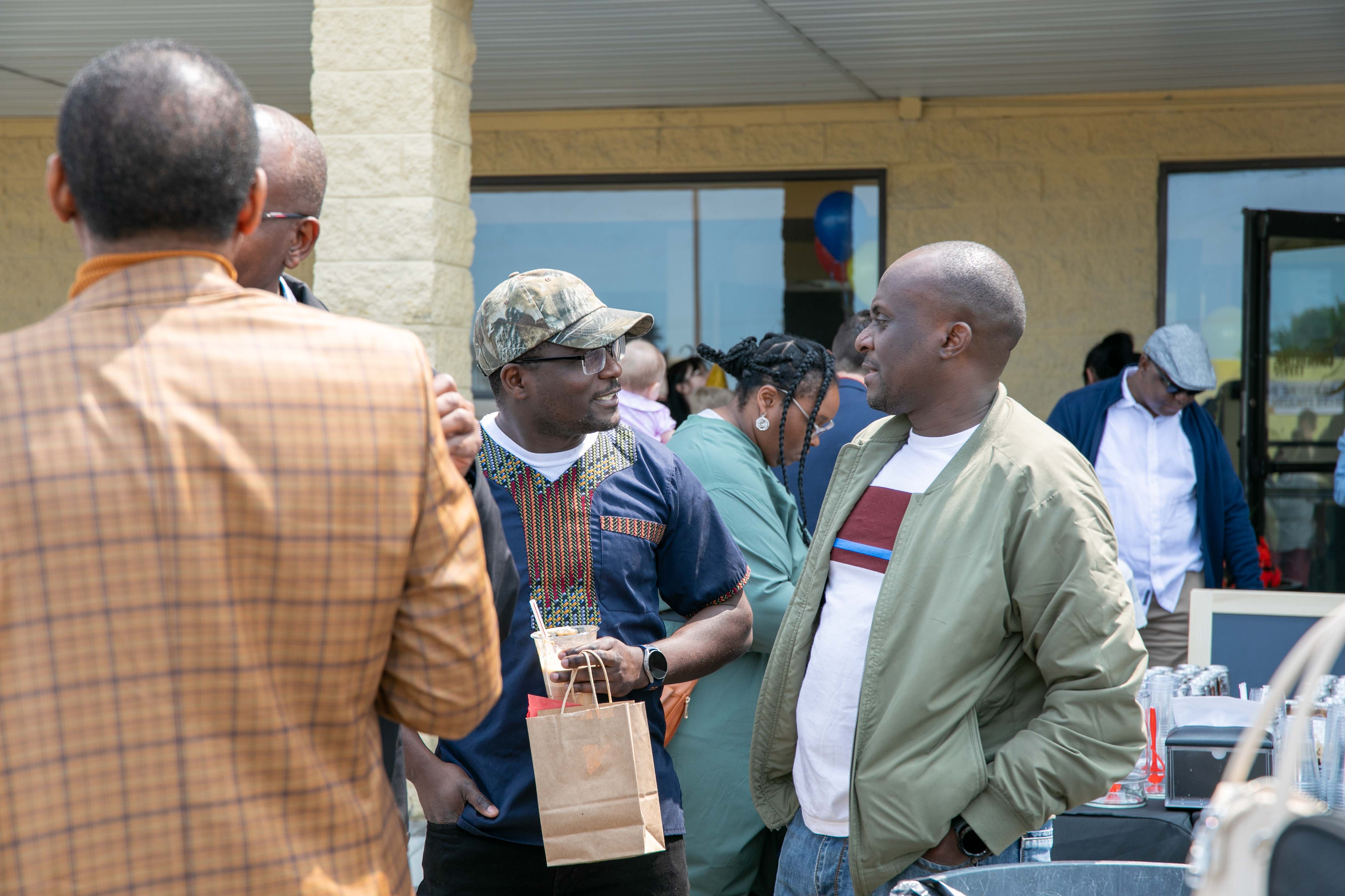 A group of men chatting outside of a building