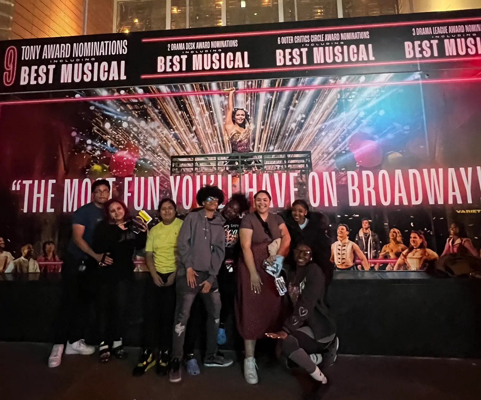 Students posing in front of a Broadway Best Musical show banner