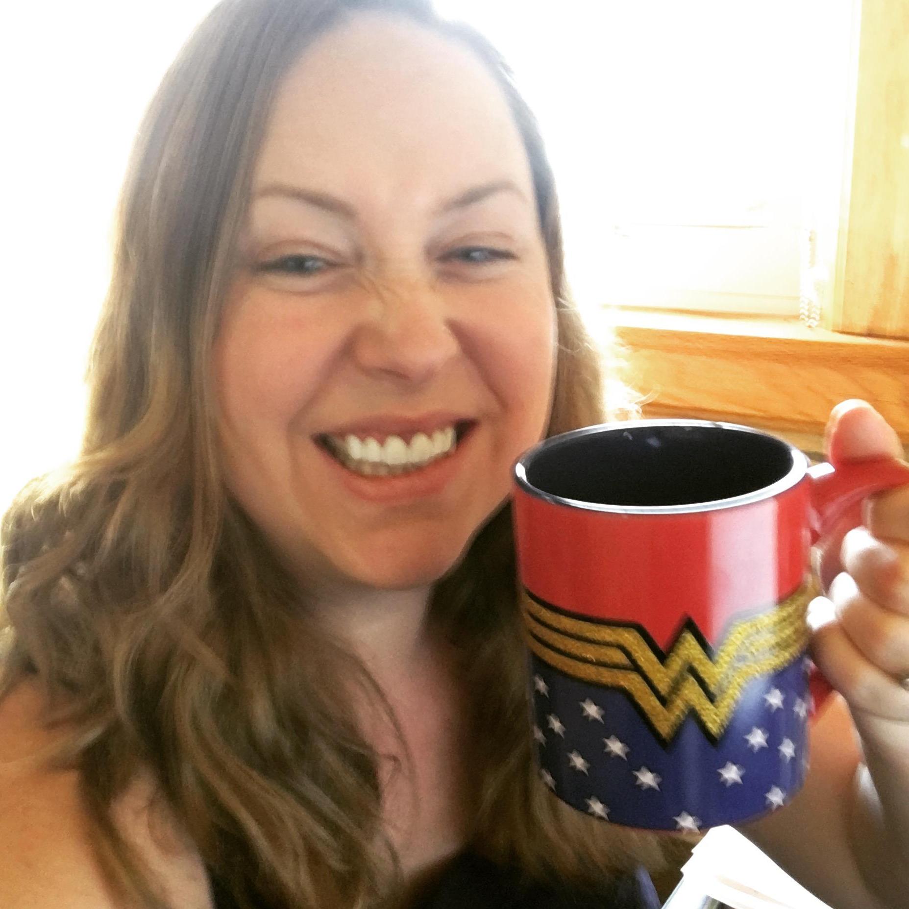 Ms. Perkins smiling and holding a Wonder Woman mug