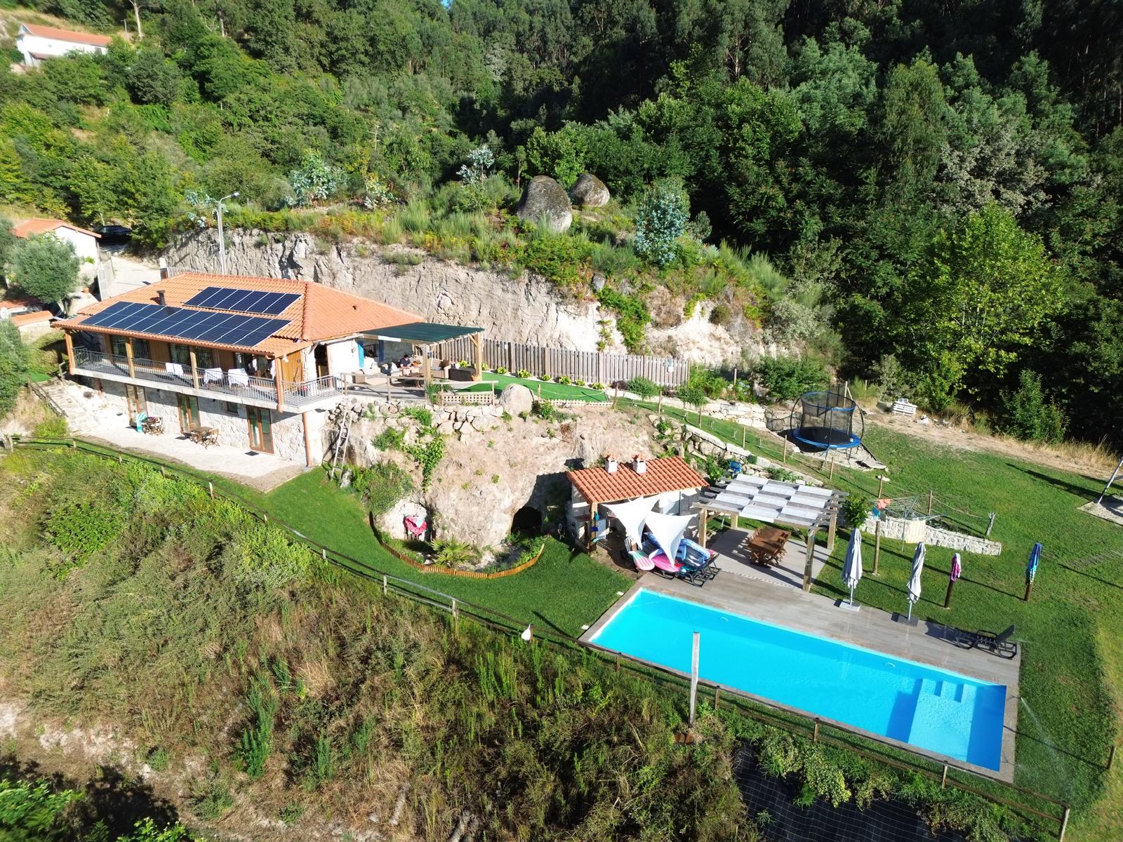 Man and woman standing across from each other at a white desk with an iMac and potted plants, both looking down pensively.
