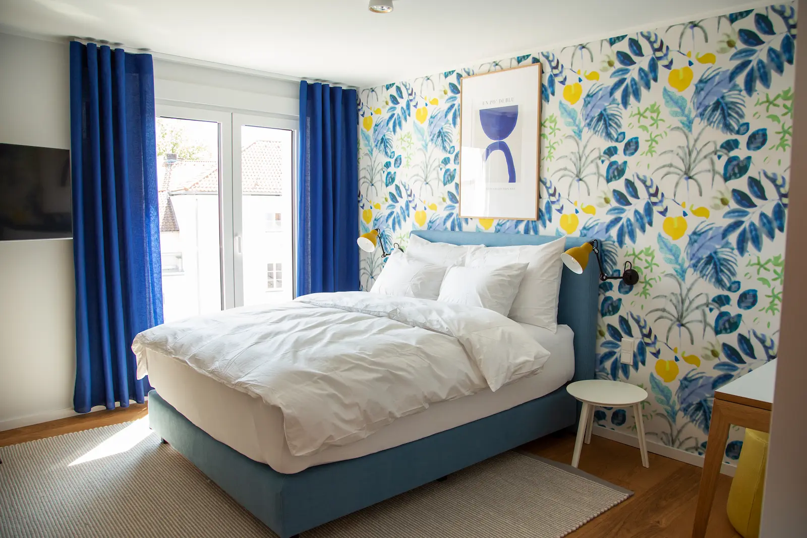 Schlafbereich mit blauen Vorhängen im Deluxe Studio, 21rooms Ingolstadt