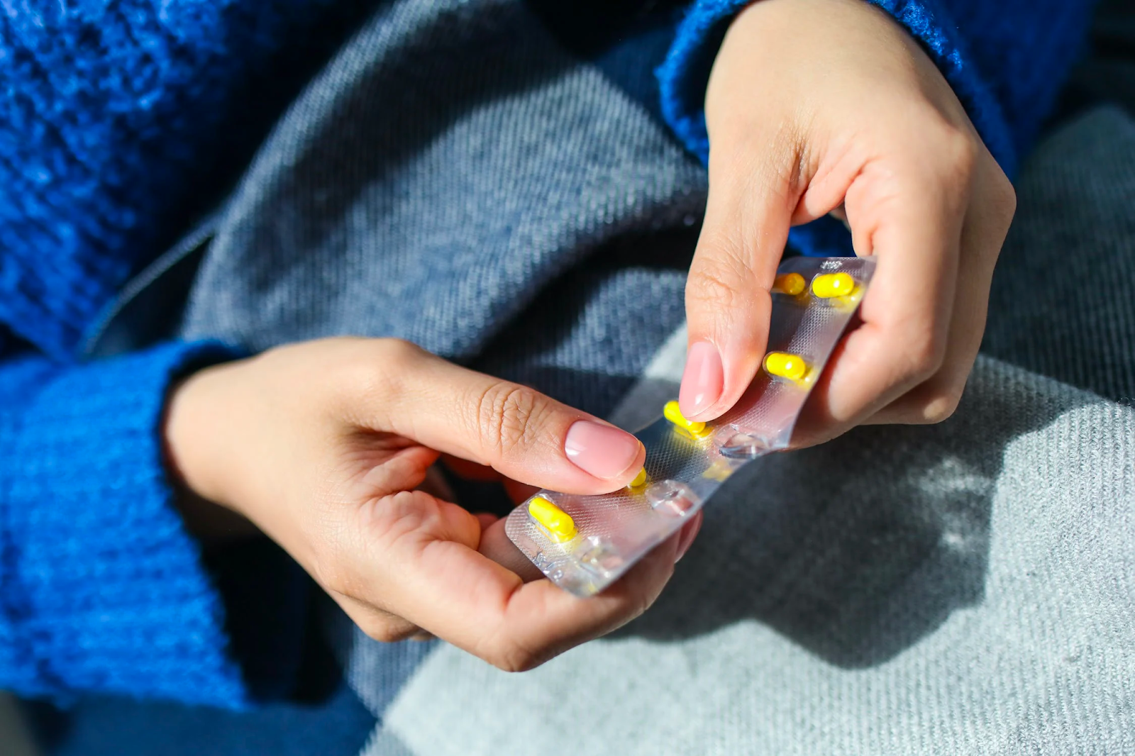 A woman holding up a pill