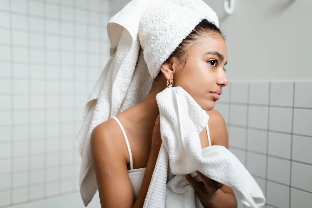 Woman drying skin with a white towel