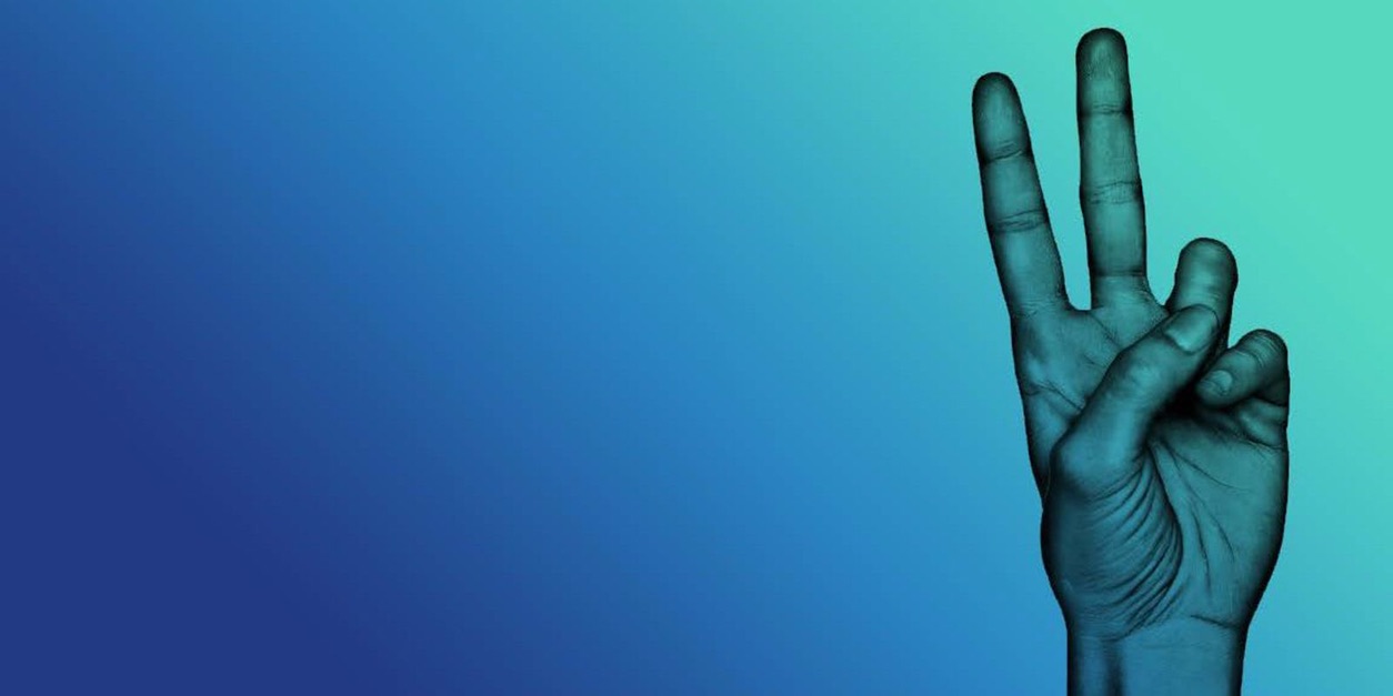 A hand holding up three fingers