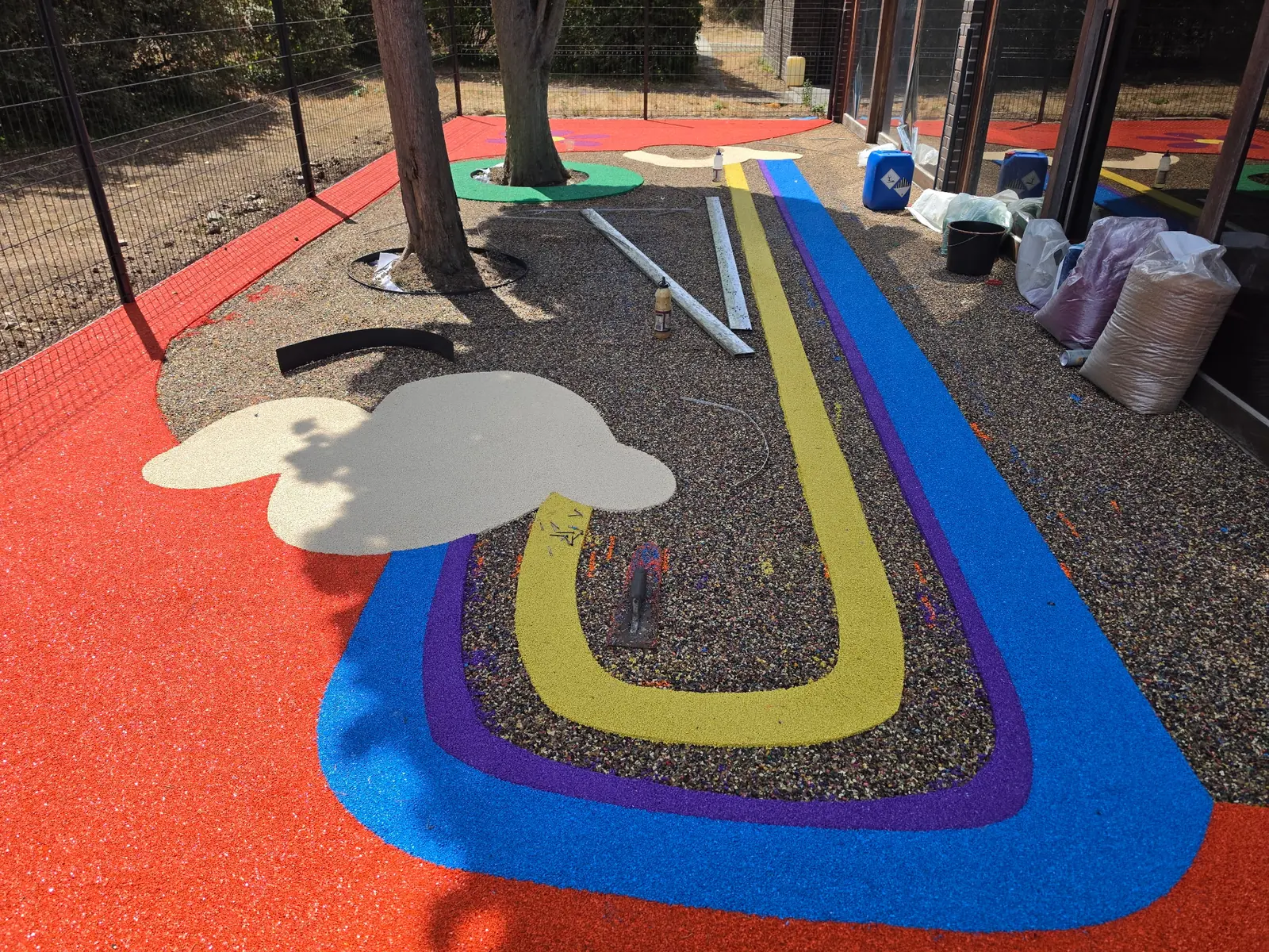 Application de bandes de couleur et de motifs dans un sol amortissant, chantier en cours