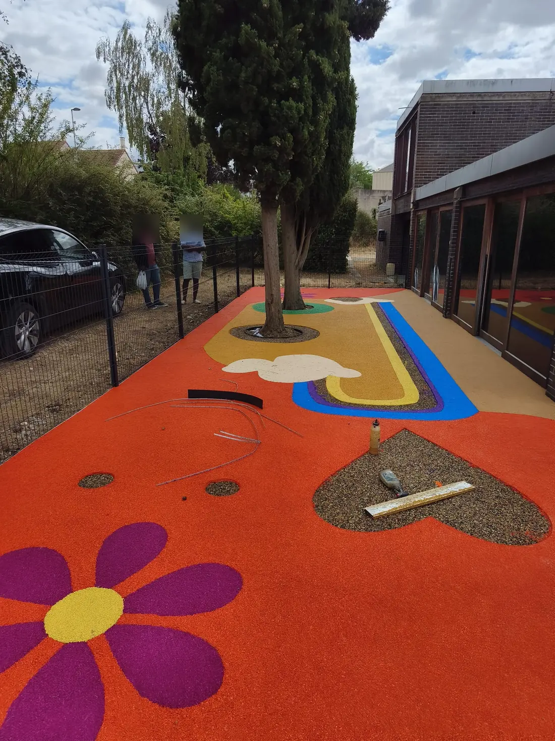 Cour de crèche avec sol amortissant orange et grande fleur violette