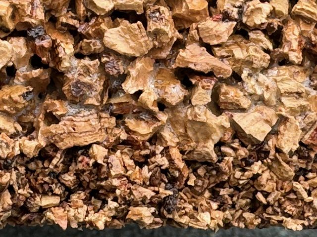 Coupe d'un sol amortissant en liège : granulats de liège naturel liés par résine polyuréthane