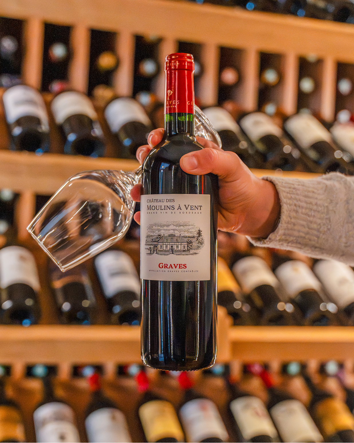 Photography of a bottle, warm setting, a hand holding the bottle