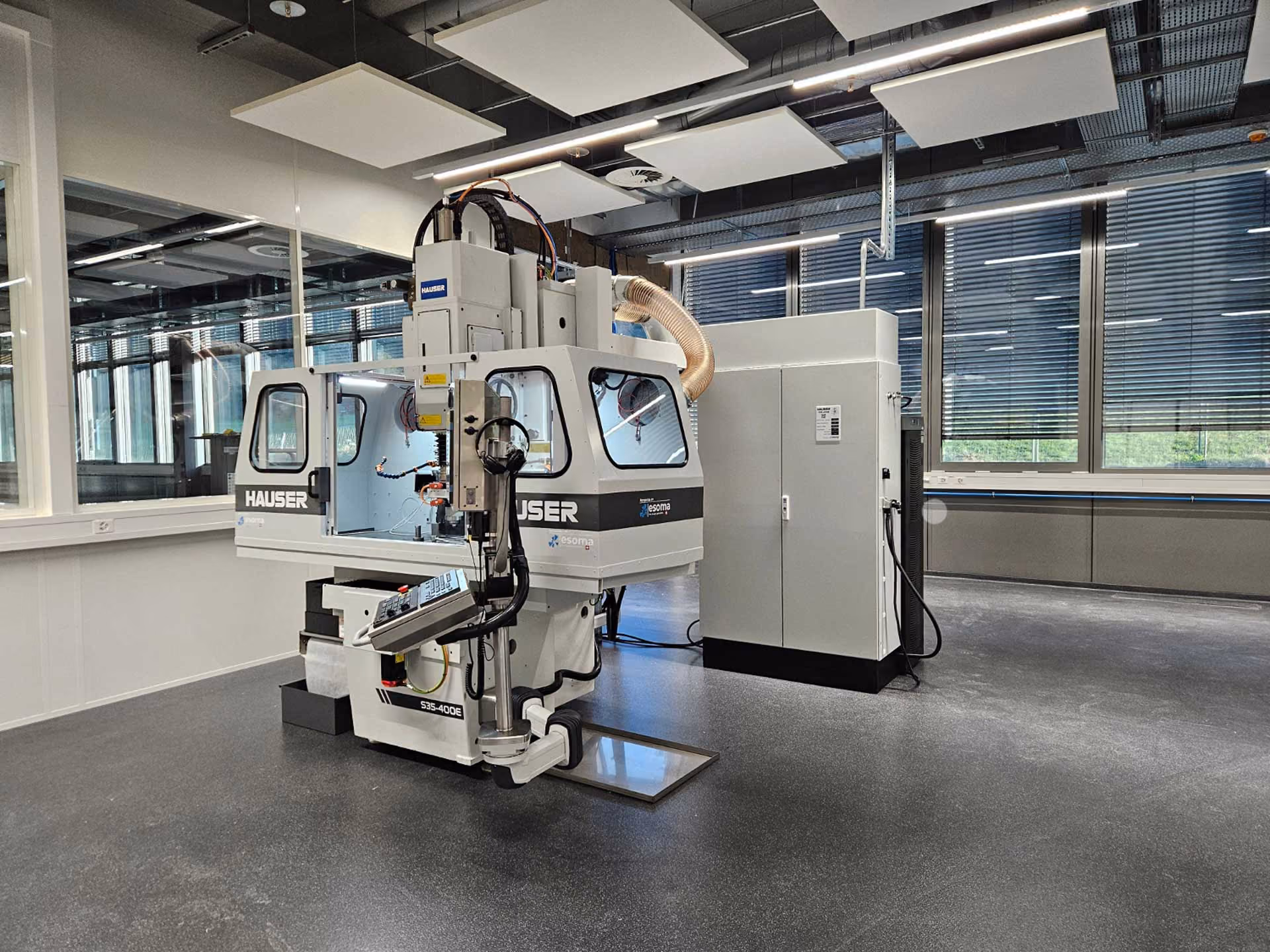 Industrielle Hauser-Maschine im modernen, sauberen Werkstattatelier mit großen Fenstern.
