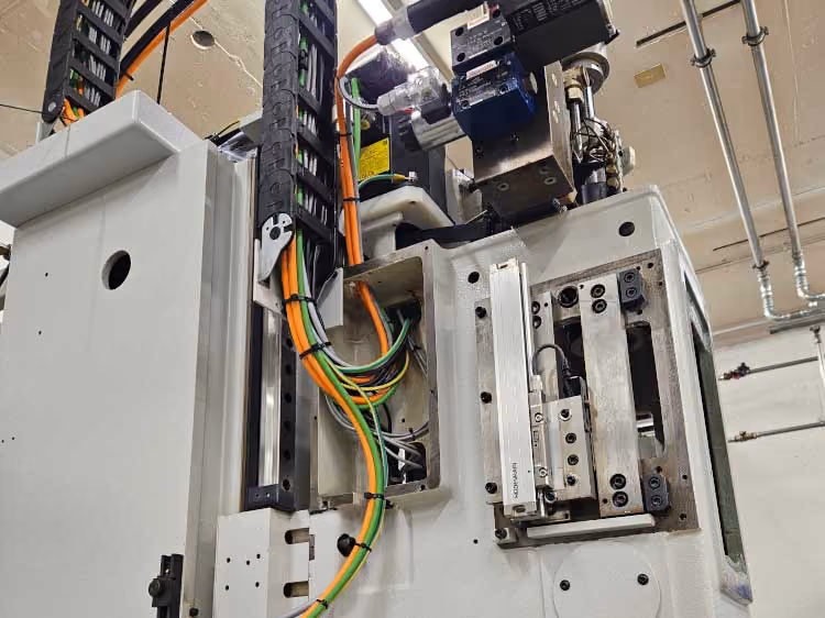 Innenseite eines geöffneten Elektroschranks mit Kabeln und technischen Bauteilen.