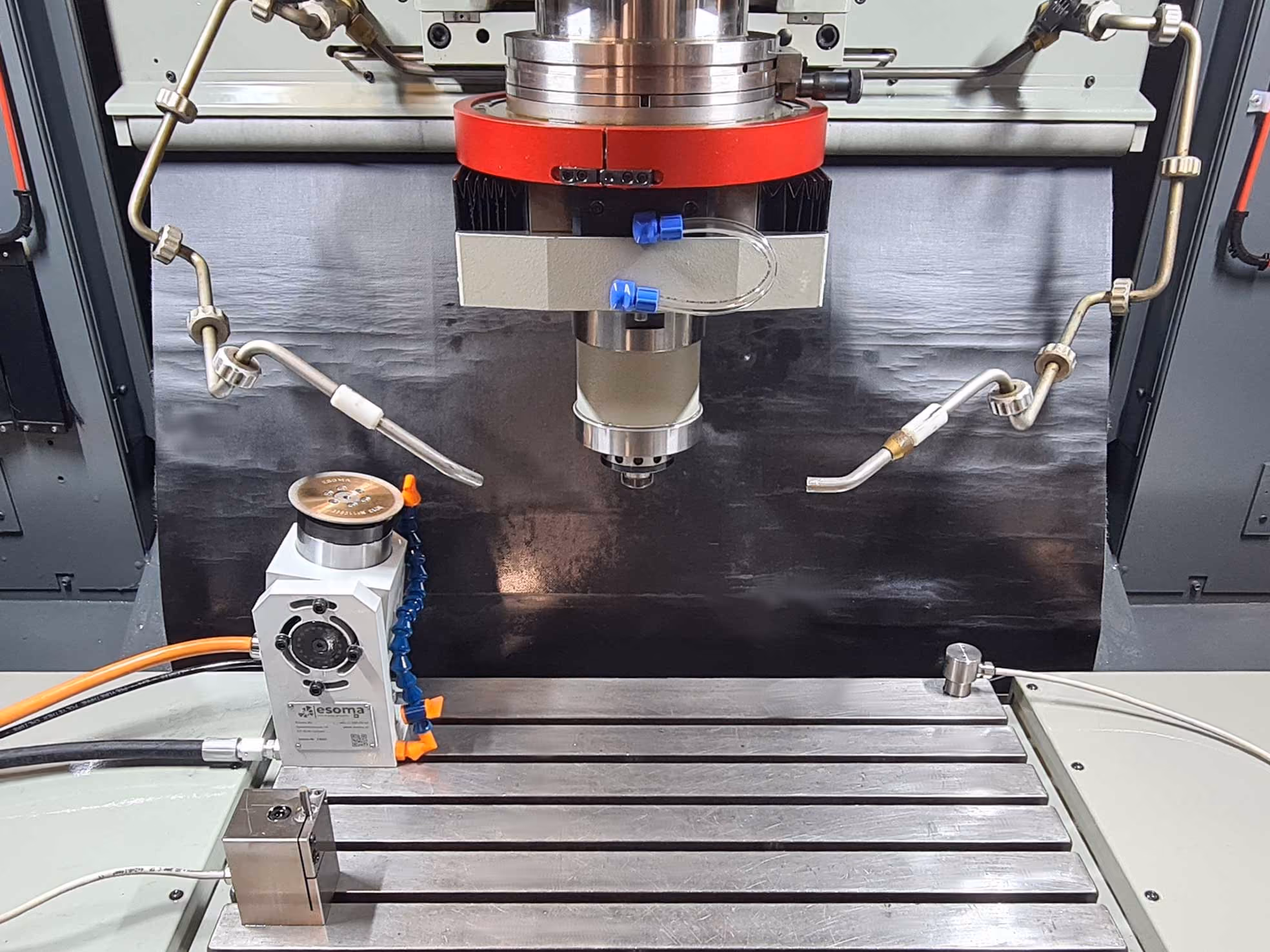 Industrielle Fräsmaschine mit Metallisch-Tisch, Kühlmittelschläuchen und Spindel für Präzisionsbearbeitung.