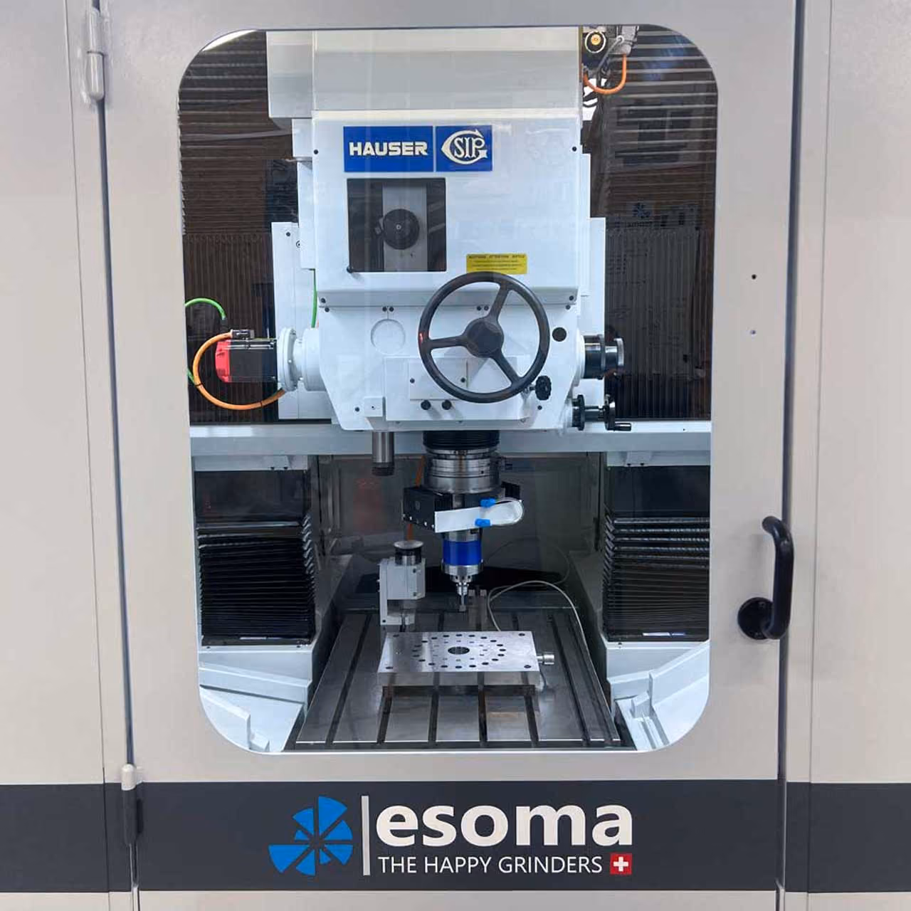 Industrielle Schleifmaschine Esoma mit Steuerung und Werkstückbefestigung im Sichtfenster.