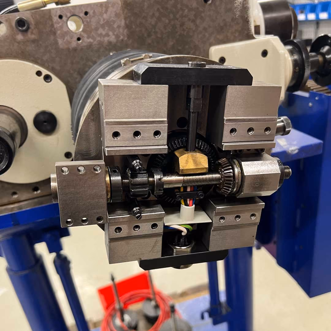Metallmechanische Maschine mit Zahnrad, Gewindespindel und mehreren Schraubverbindungen in Werkstatt.