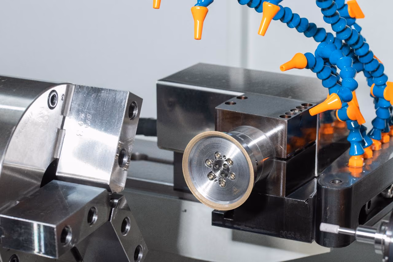 Metallbearbeitungsmaschine mit Spannfutter und flexiblem Kühlmittelschlauch in Blau und Orange.