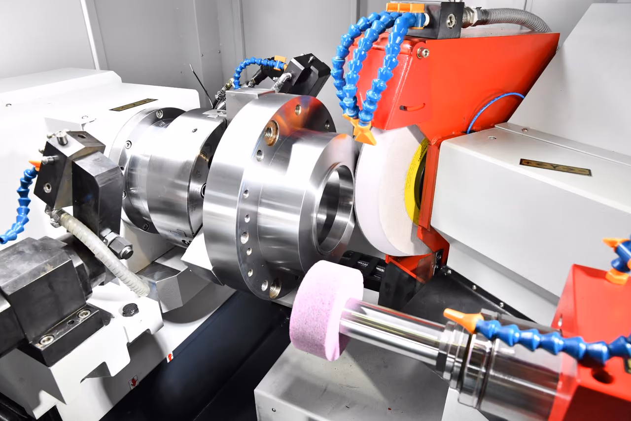 Industrielle Maschine mit Drehvorrichtung und Schleifscheiben zum Metallschleifen.