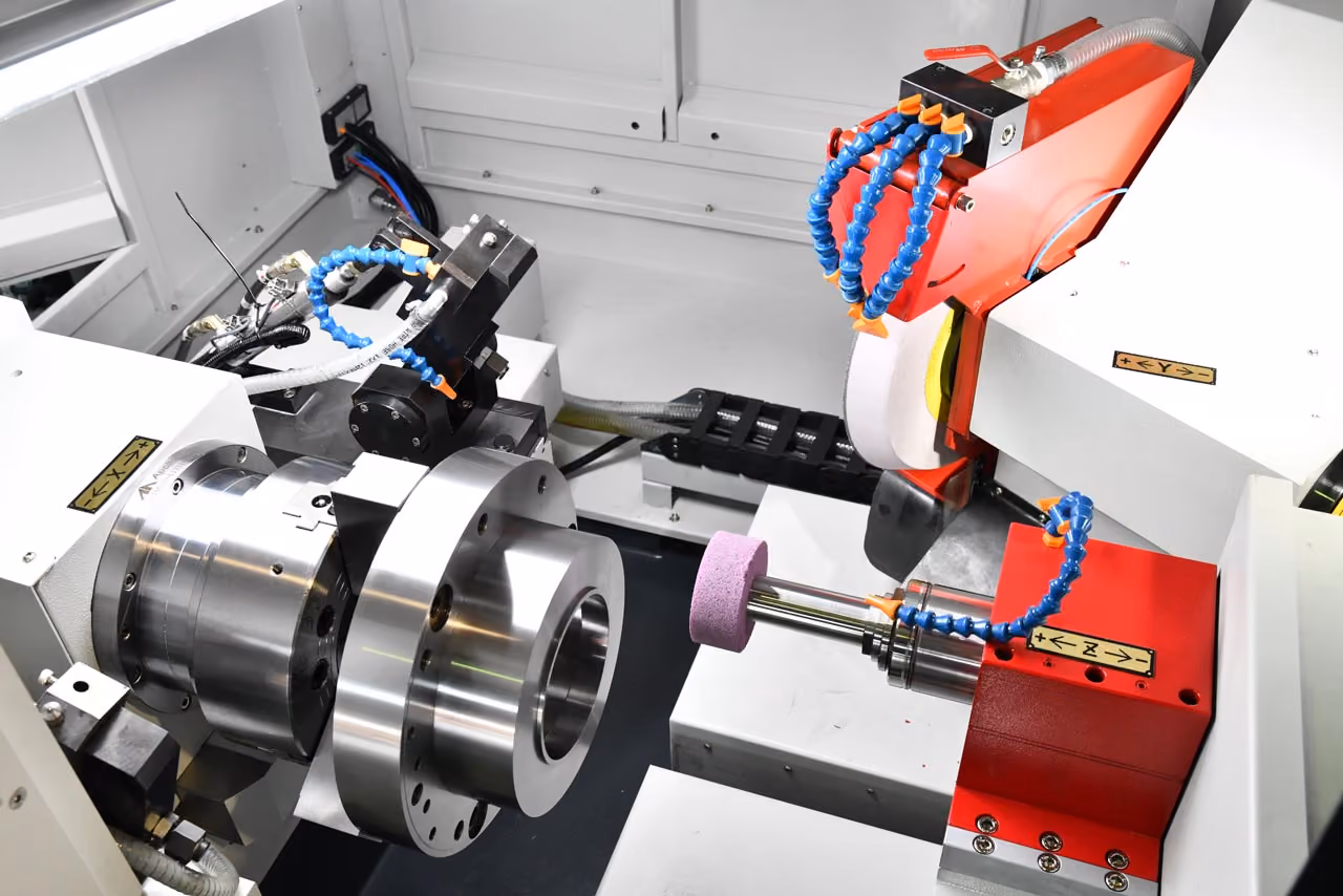 Industrielle Maschine mit rotierenden Komponenten und Schleifscheiben im weißen Gehäuse.