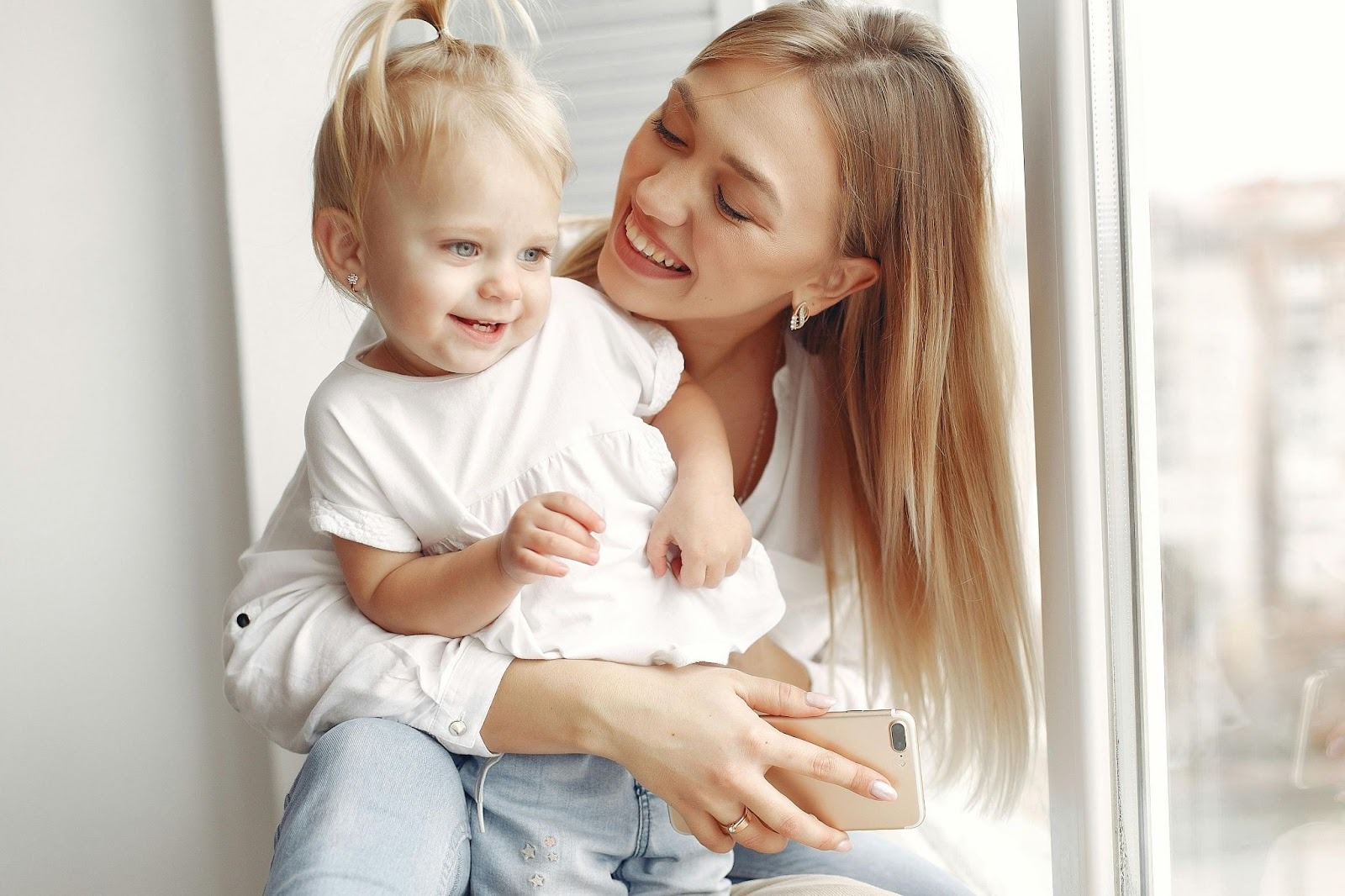 Professional nanny holding a toddler during a calm, engaged moment that reflects trust, structure, and intentional caregiving