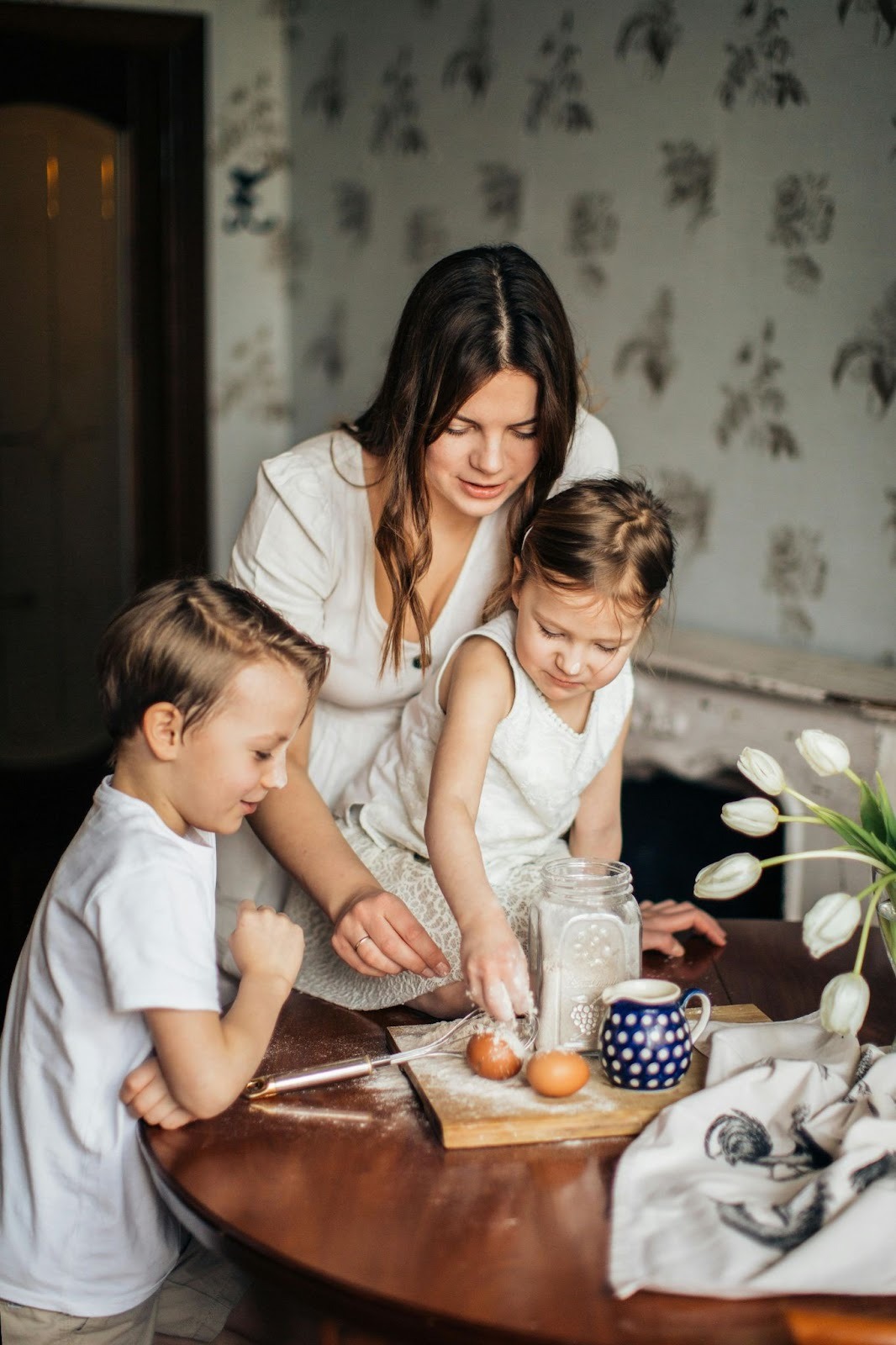 Caregiver guiding two young children through a quiet activity at home, reflecting the judgment, trust, and long-term stability families seek when hiring a professional nanny in Washington, D.C