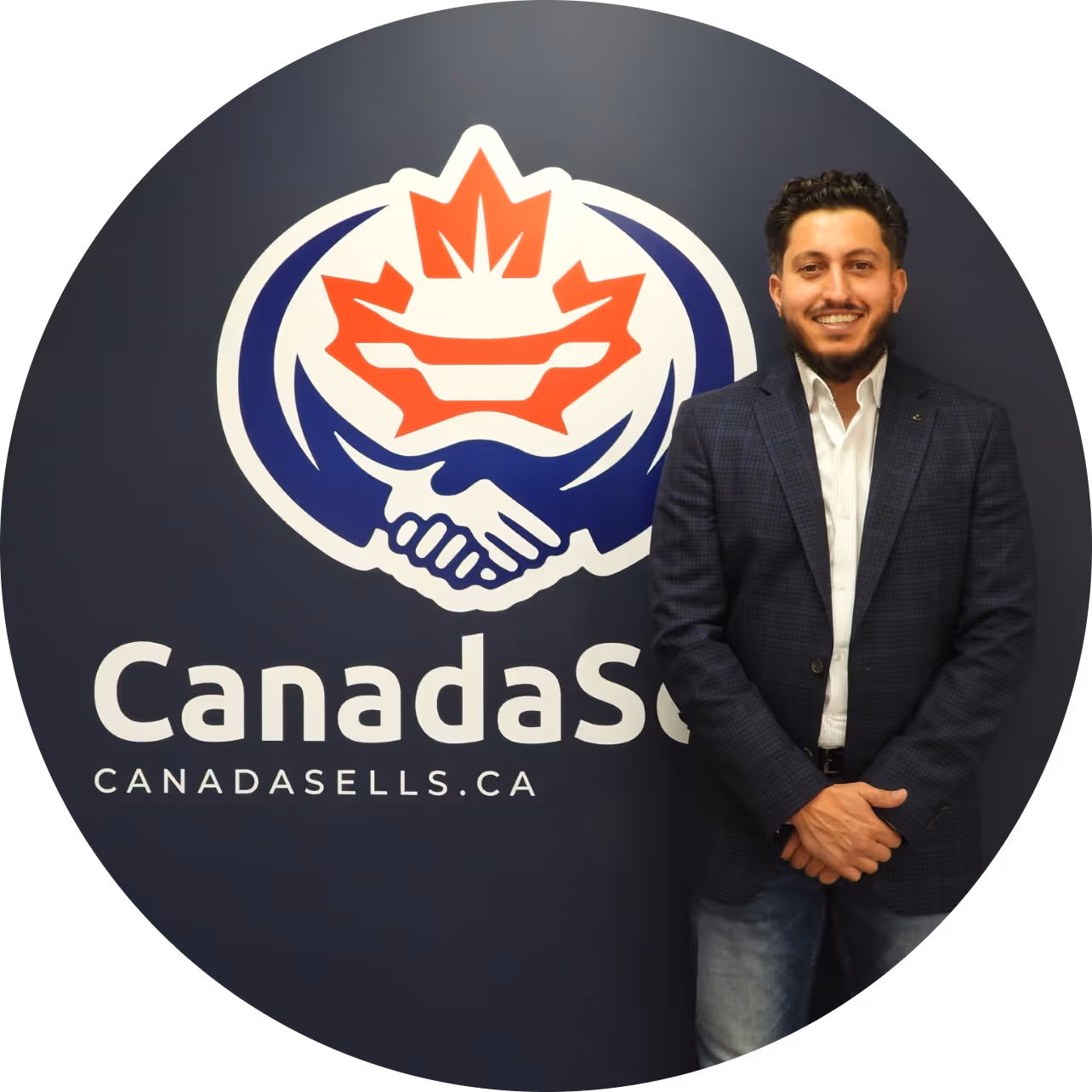 Muayad Zakkour from the Canada Sells team standing beside the company logo