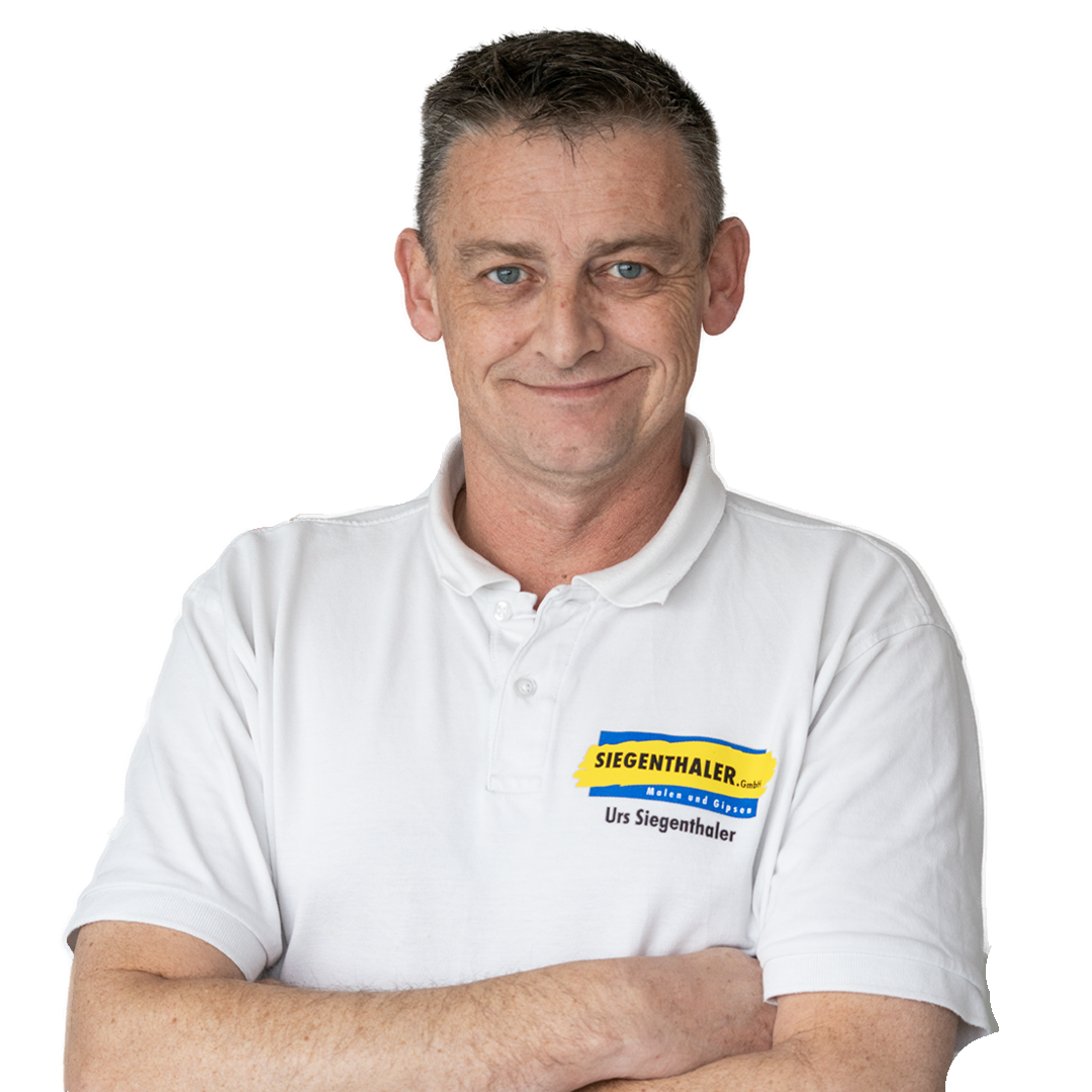 Mann mit weissem Poloshirt mit Logo von Siegenthaler GmbH und dem Namen Urs Siegenthaler, verschränkte Arme, lächelnd.