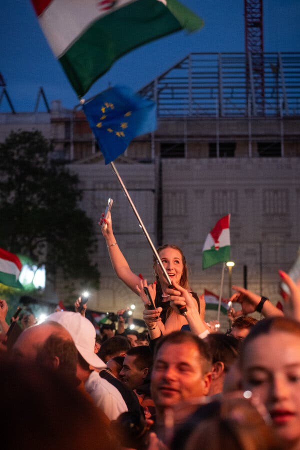 First photo: A crowd dances and waves amid flags of Hungary and the European Union. Second photo: Some younger members of the crowd pause to rehydrate. Third photo: A hand wearing a red, white and green wristband.