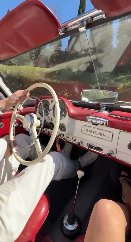 Four skiers standing close together in snowy forest with snow splashing around them.
