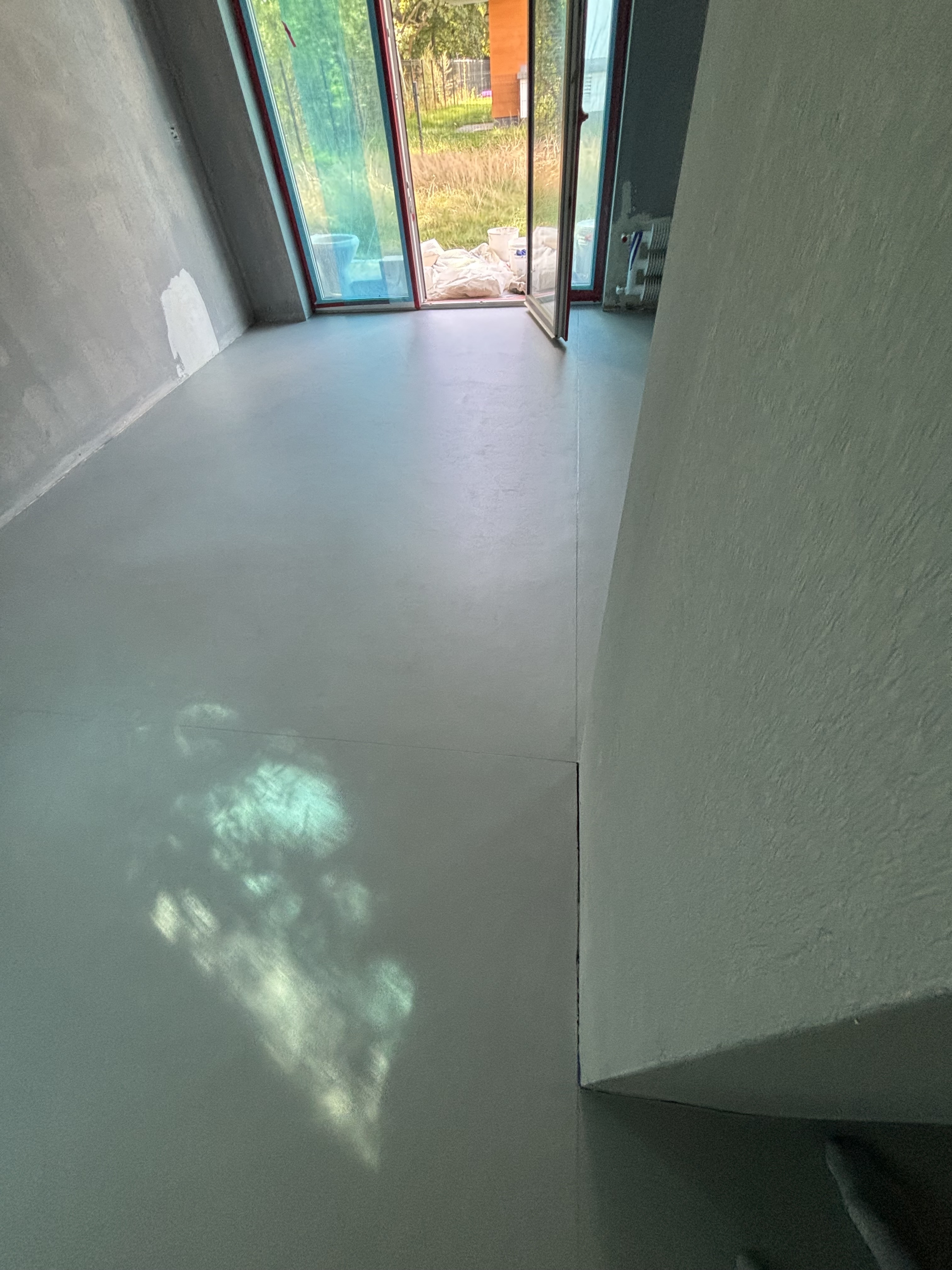 Loftowe wnętrze z mikrocementem – posadzka w salonie