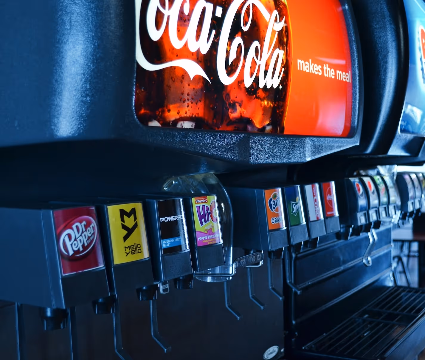 Row of soda dispensers including Dr Pepper, Mello Yello, Powerade, Hi-C, Fanta Orange, and Sprite.