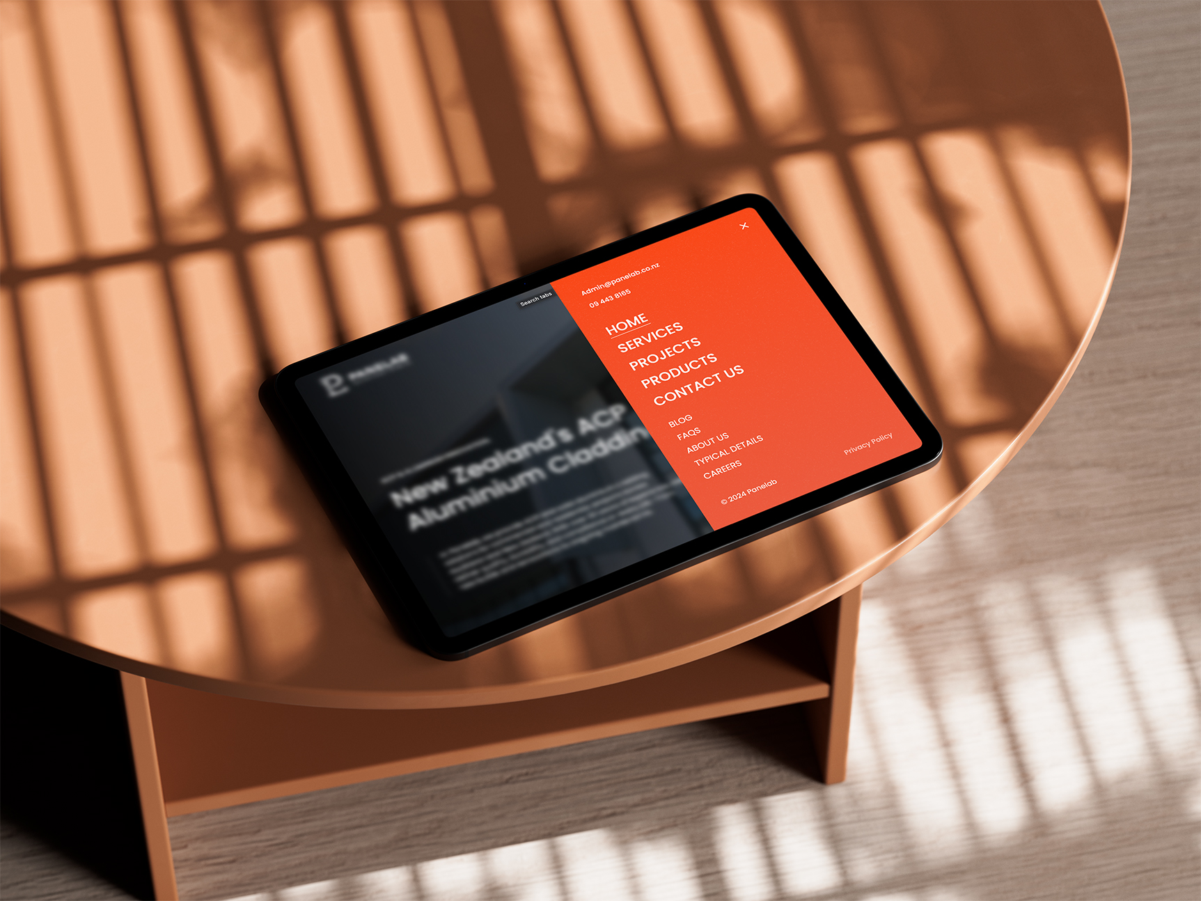 Panel website shown on an ipad sitting on a coffee table in a well lit room