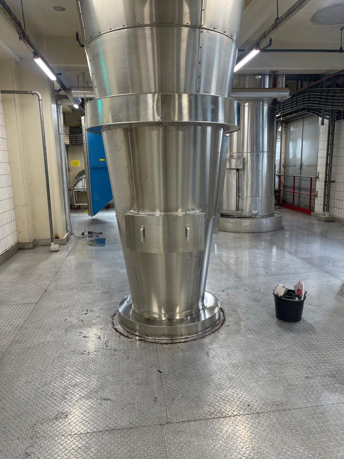 Conische onderzijde van een procesvat afgewerkt met aluminium beplating in een schone proceshal