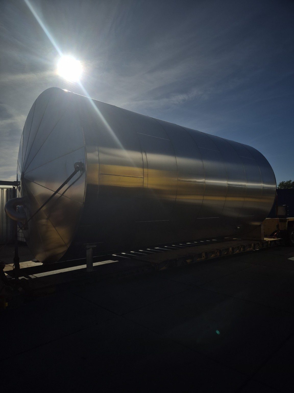 Grote met aluminium beplate tank op een transportframe, met tegenlicht van de zon