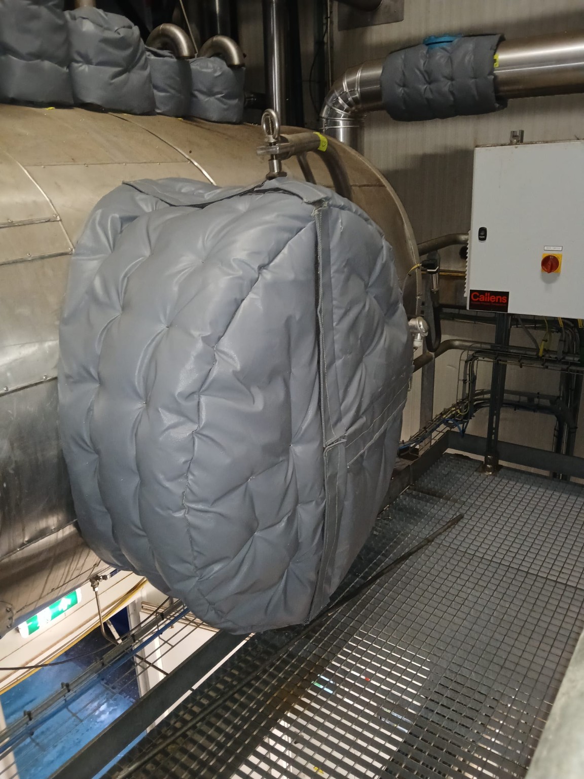 Afneembare isolatiekap op het uiteinde van een groot horizontaal vat in een technische ruimte