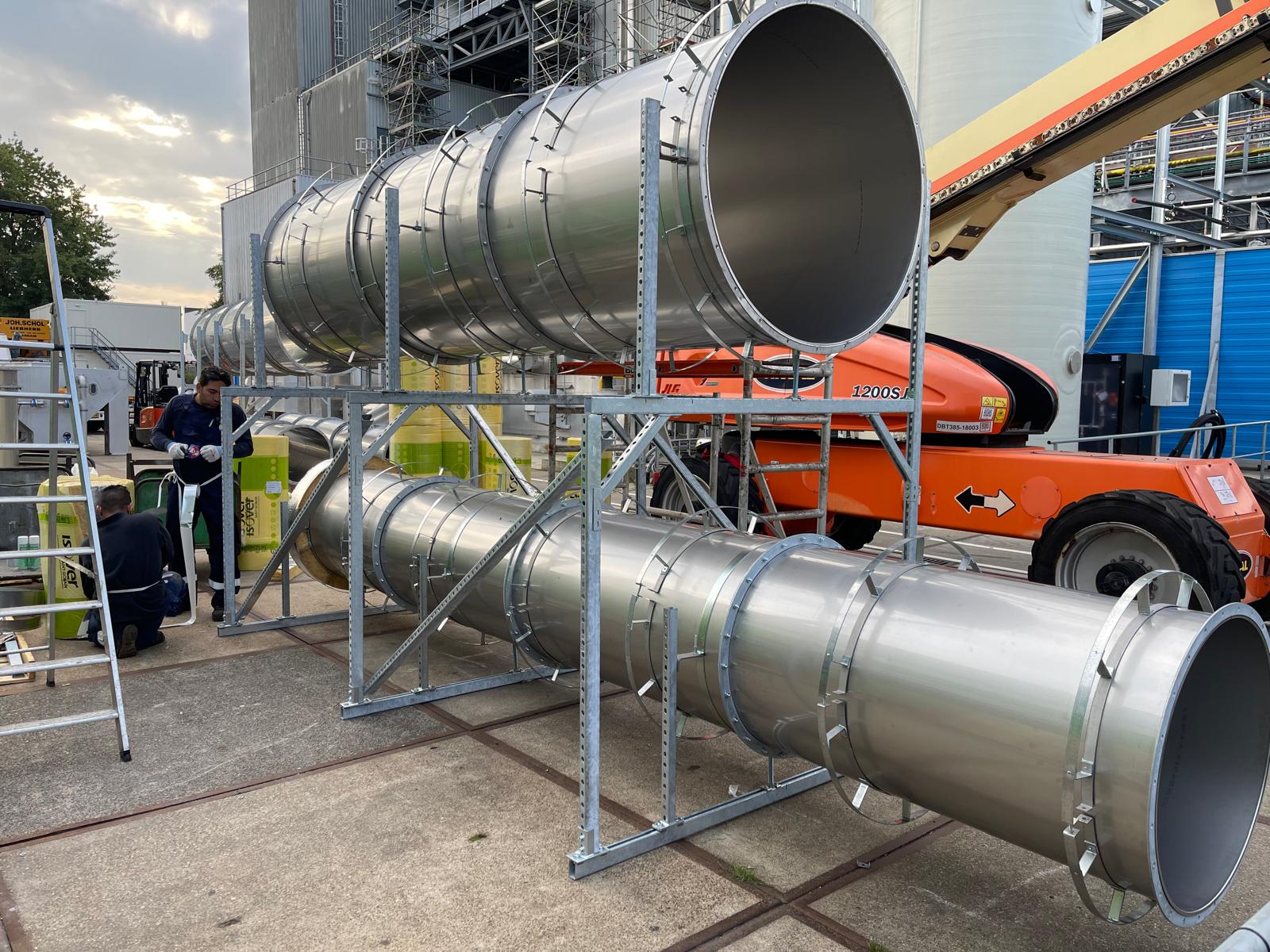 Grote, met aluminium beplate kanaaldelen op stalen ondersteuningsrekken tijdens de montage