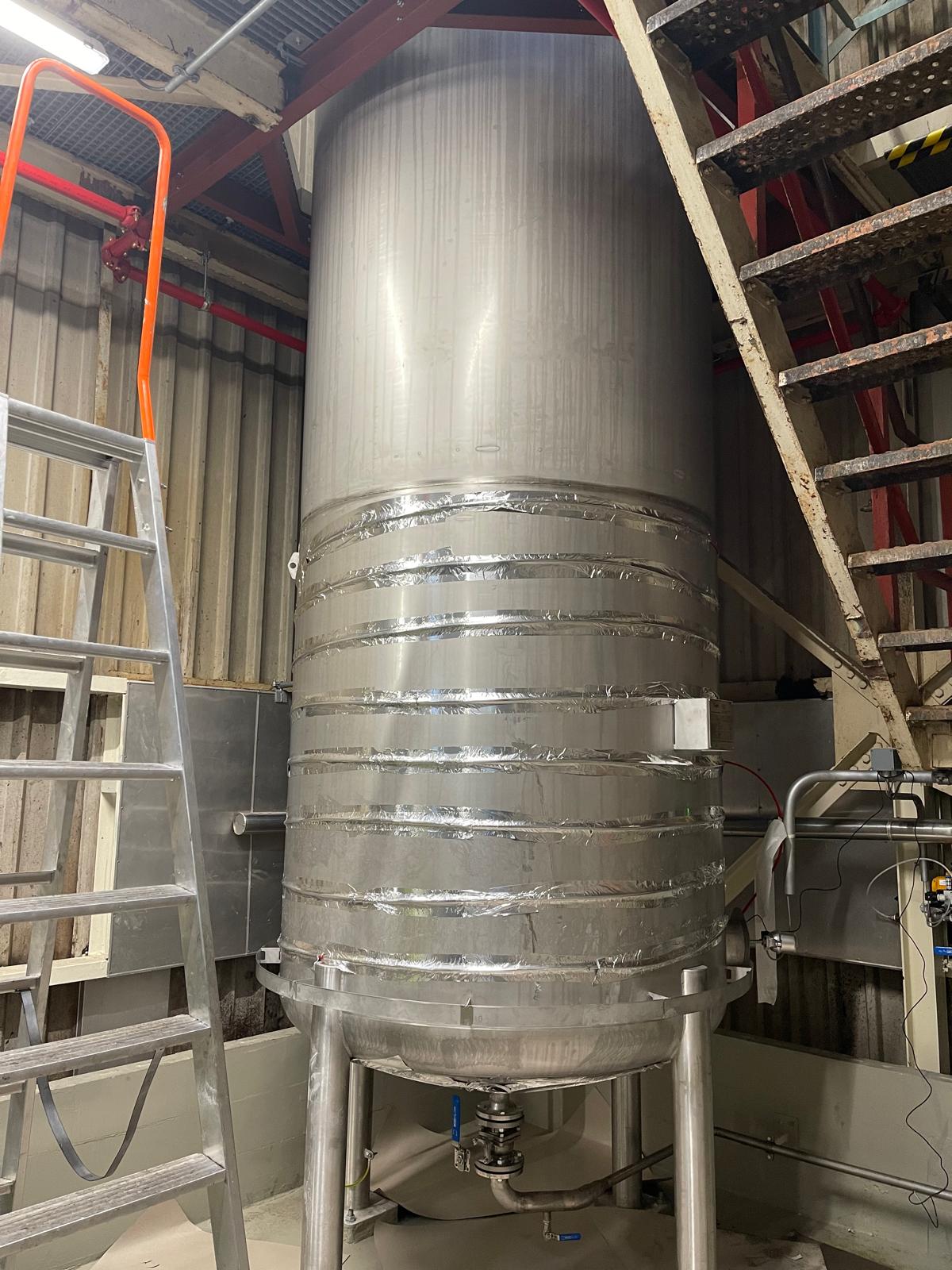 Dezelfde tank met tracingkabel die met aluminium warmteverdeeltape rond het onderste deel van de tankwand is bevestigd