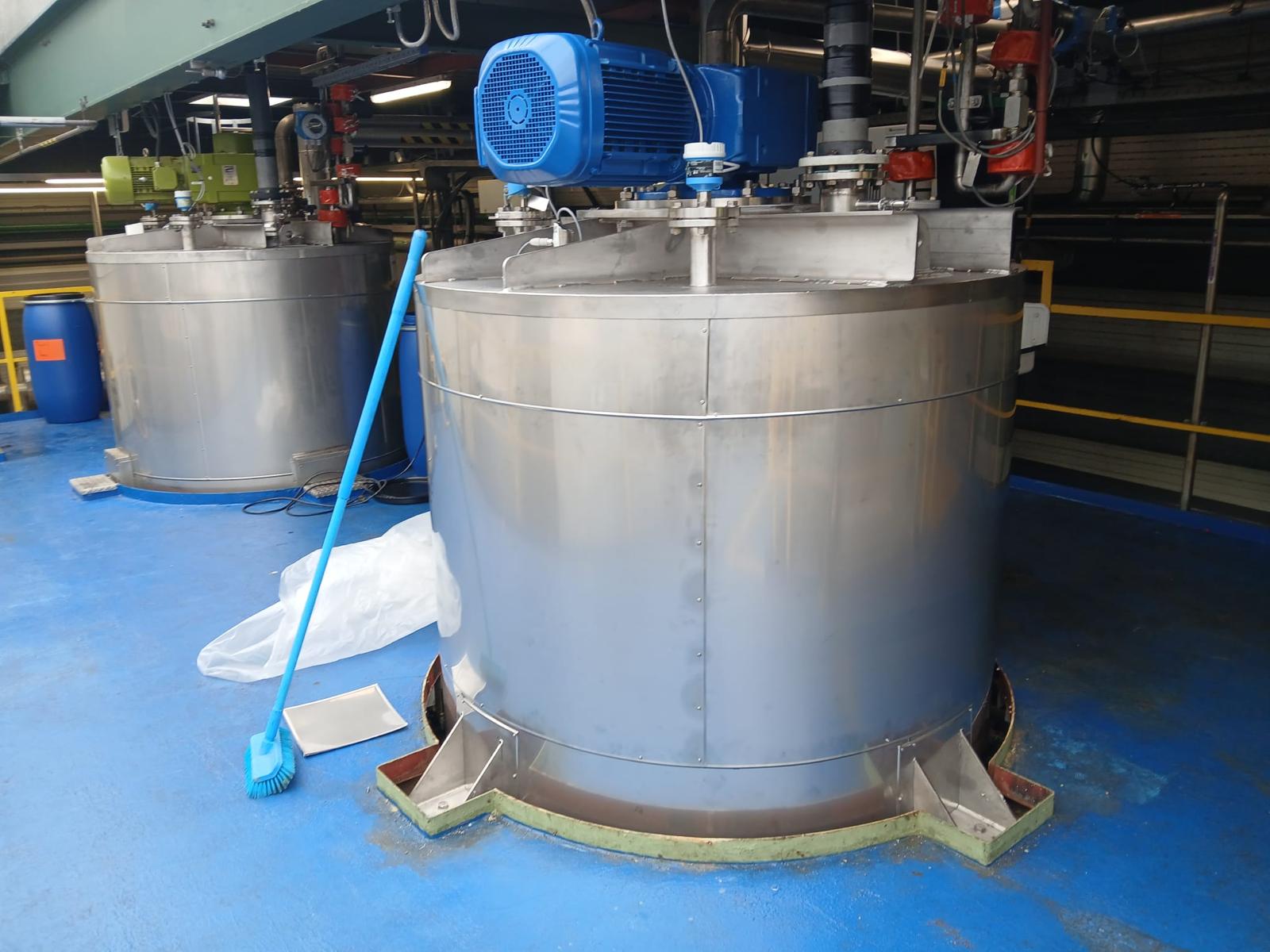 Twee procestanks afgewerkt met RVS-beplating, met roerwerkaandrijvingen bovenop gemonteerd