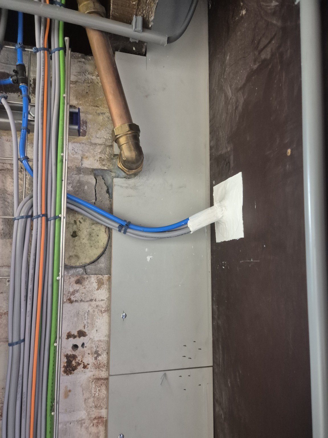 Dezelfde kabeldoorvoering gesloten met wit afdichtingsmateriaal rond de kabels