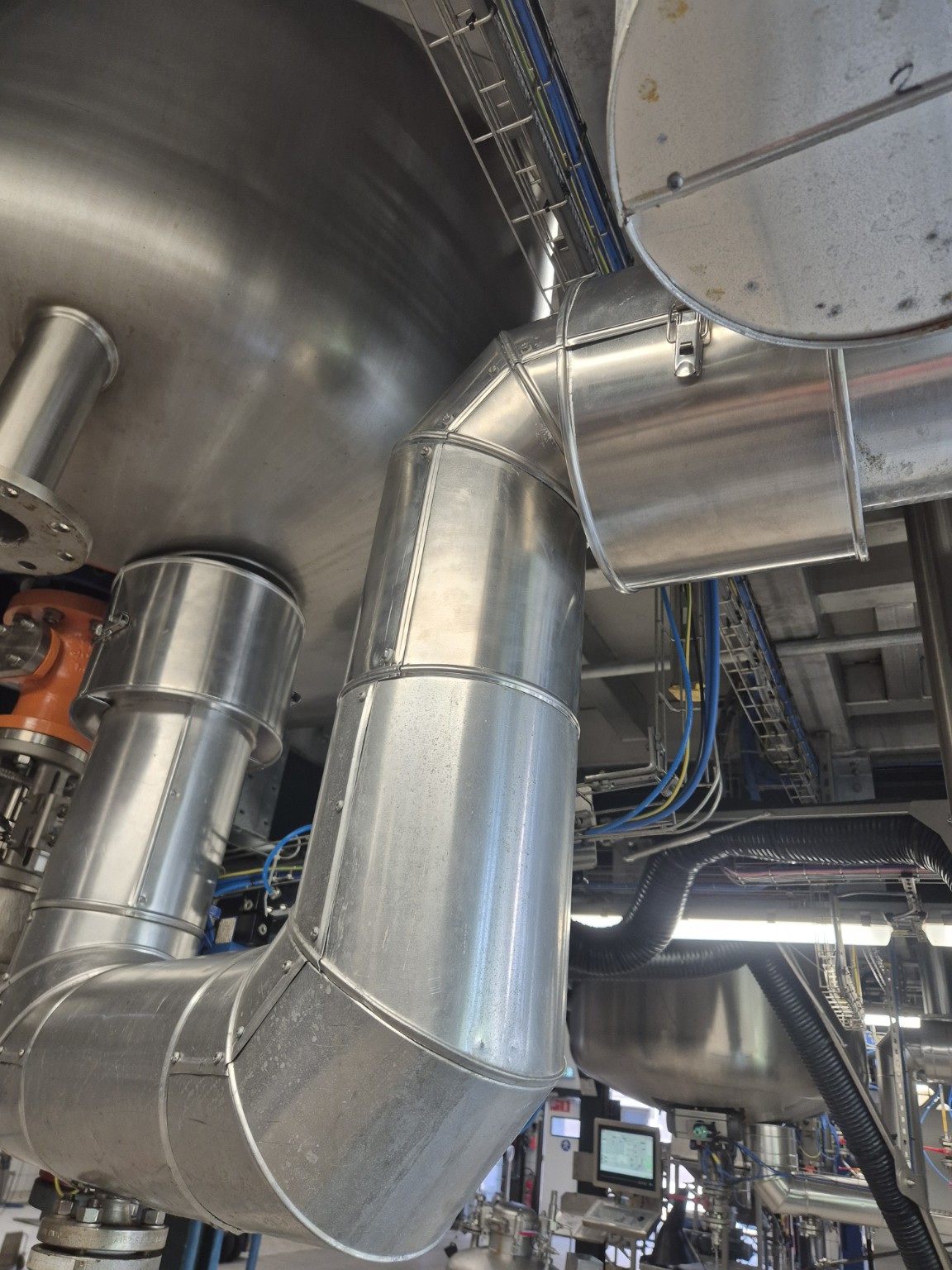 Geïsoleerde leidingbochten afgewerkt met aluminium beplating onder een RVS-procesvat