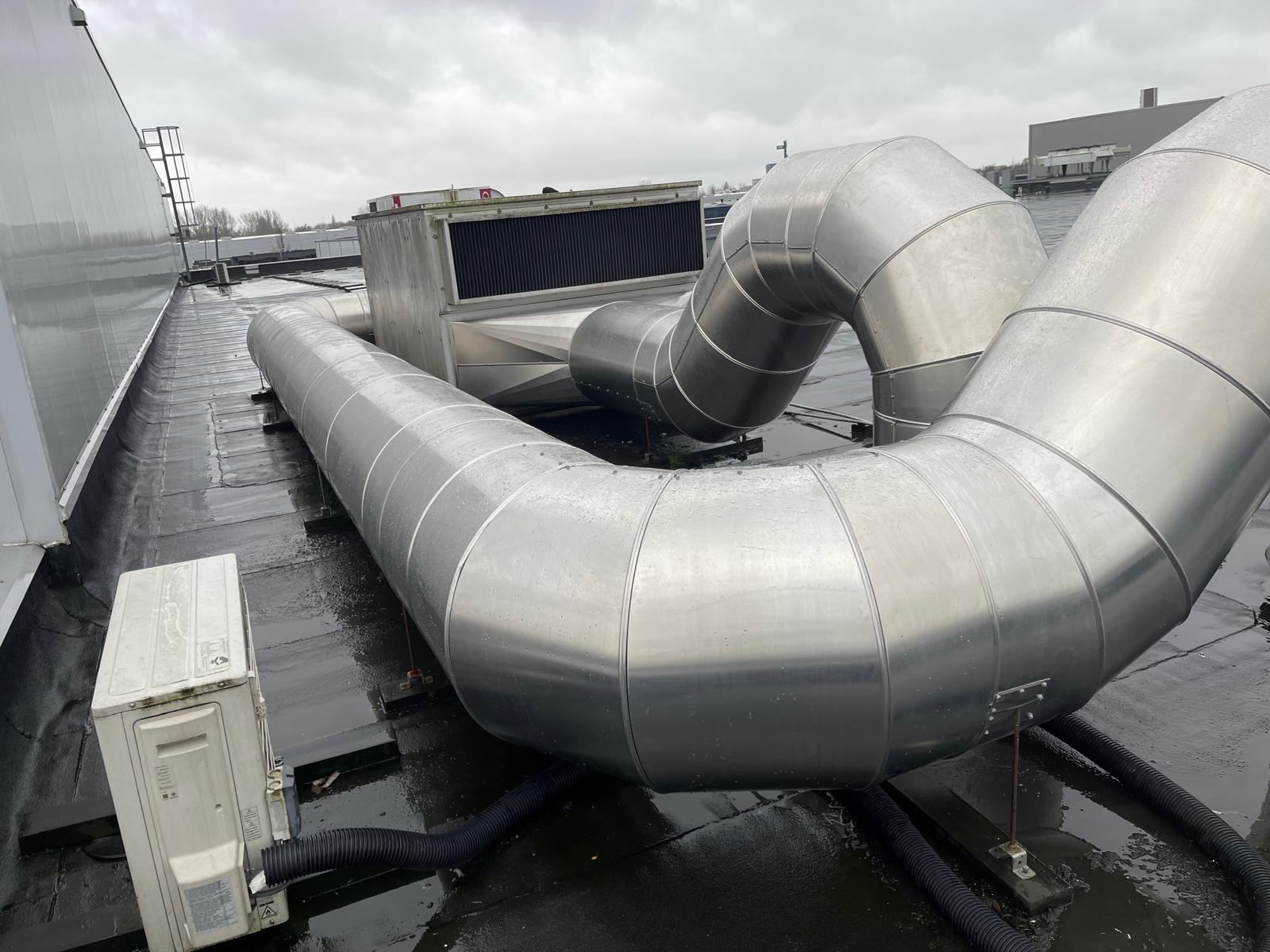 Luchtbehandelingskast op het dak met kanaalbochten en tracés afgewerkt met metalen beplating