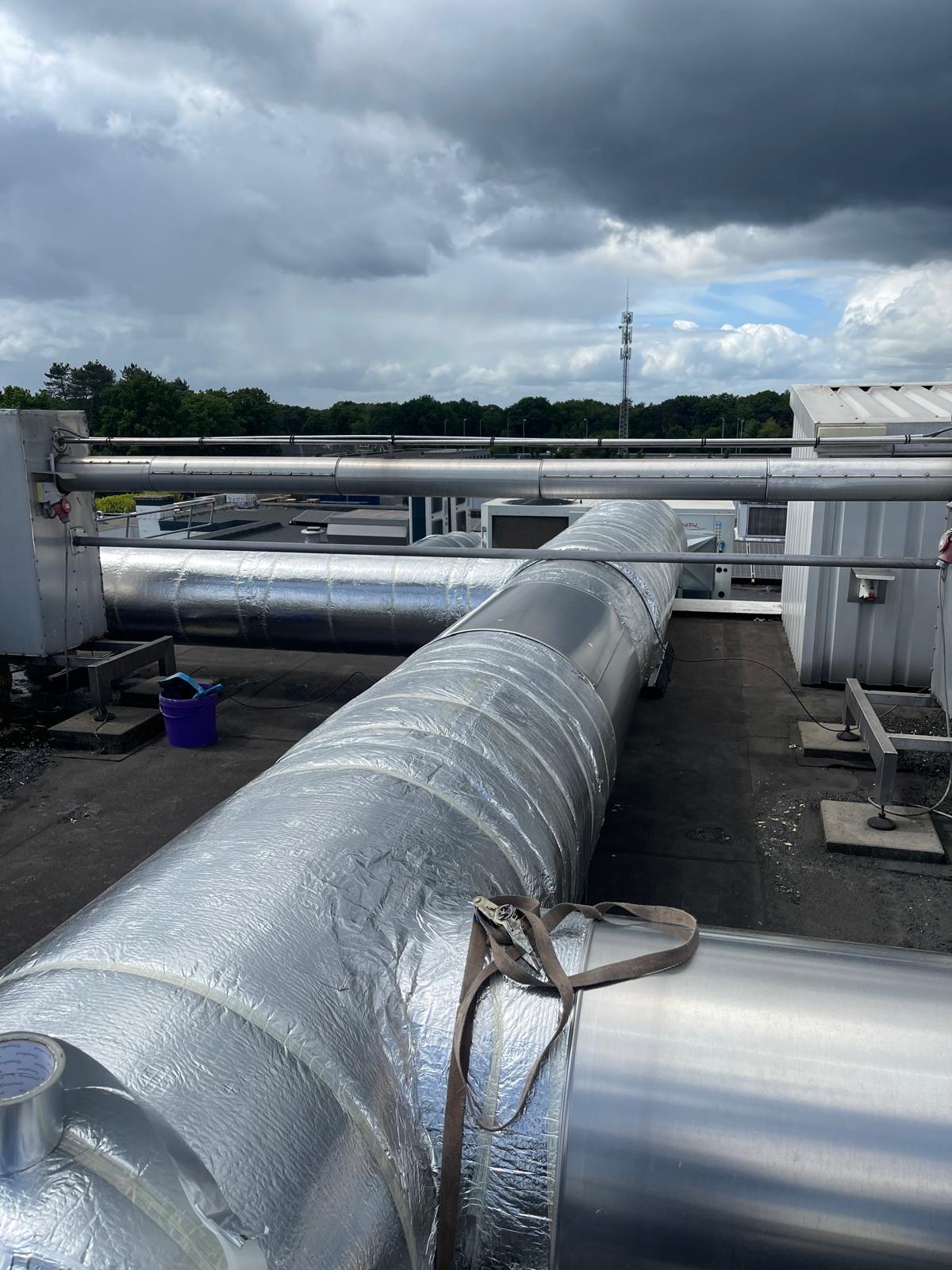 Kanaaltracé omwikkeld met foliebeklede isolatie, met ernaast een gemonteerd deel aluminium beplating