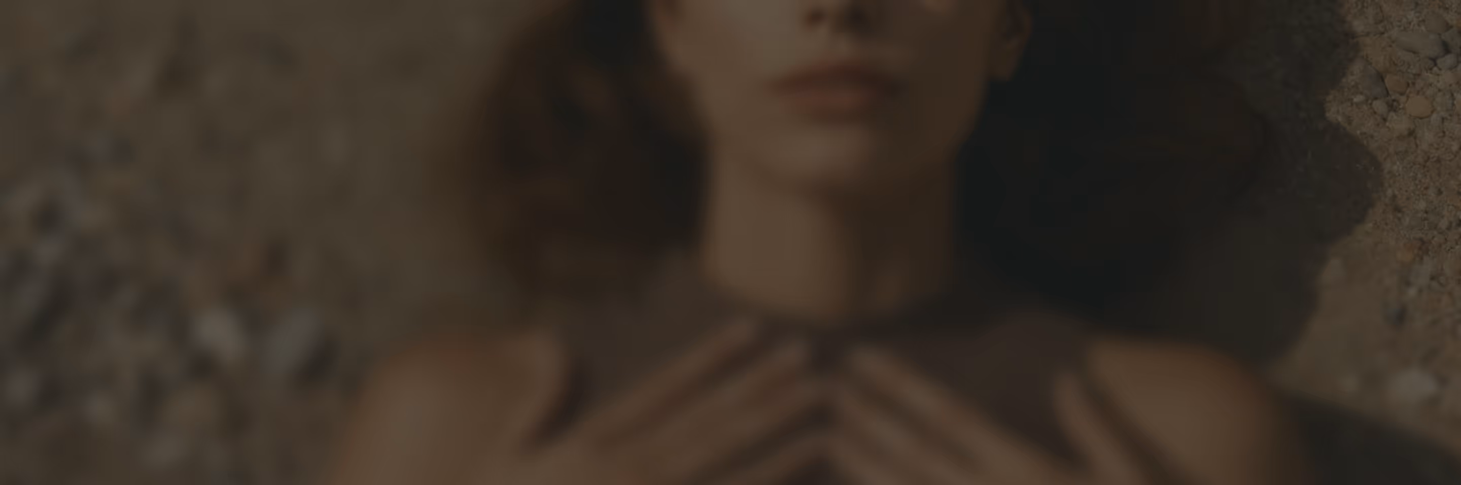 Imagen borrosa de una persona acostada en el suelo con las manos entrelazadas sobre el pecho, en señal de alivio y relajación.