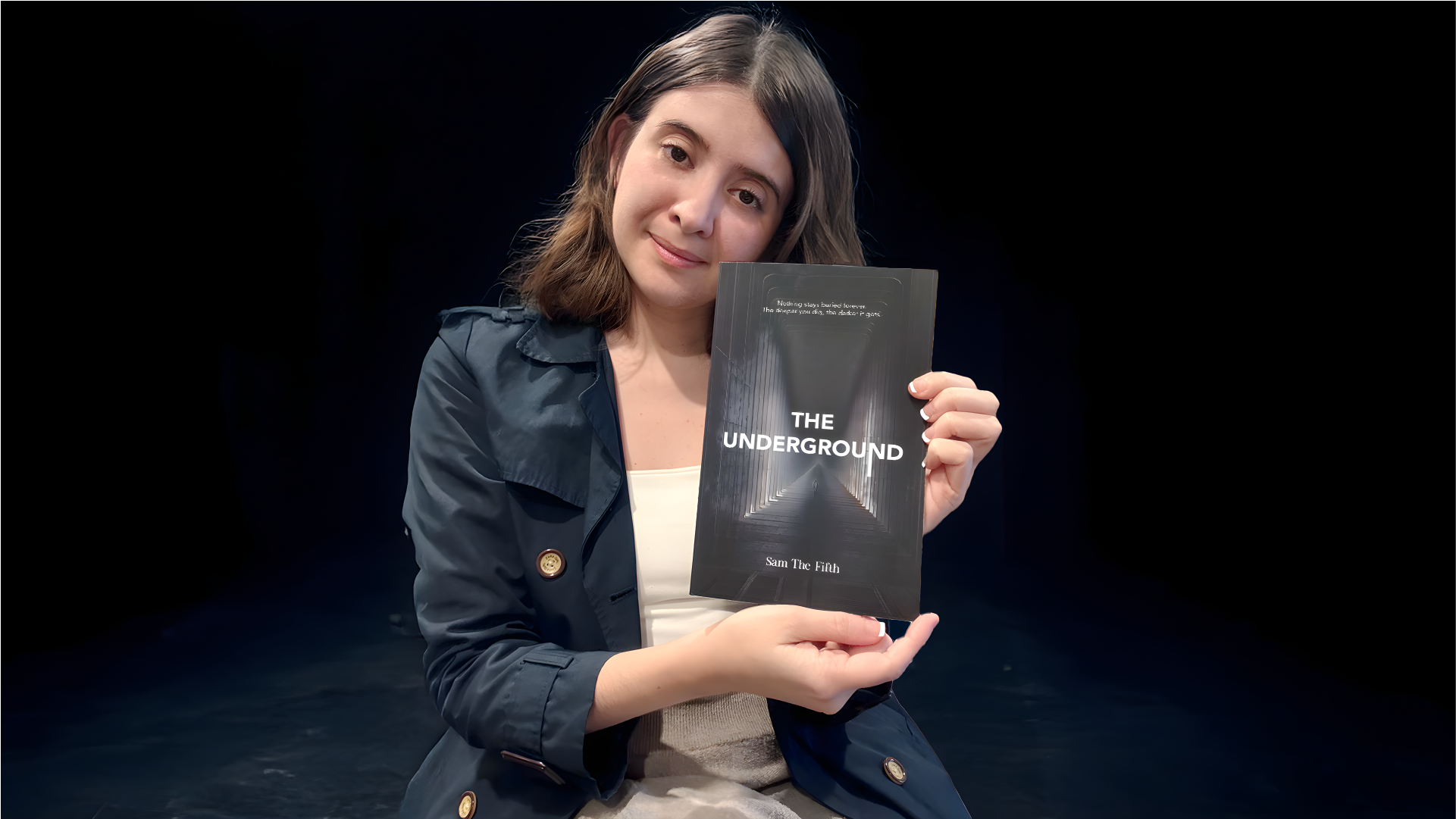 A woman with shoulder-length brown hair holds a book titled 'THE UNDERGROUND' by Sam The Fifth against a dark background.
