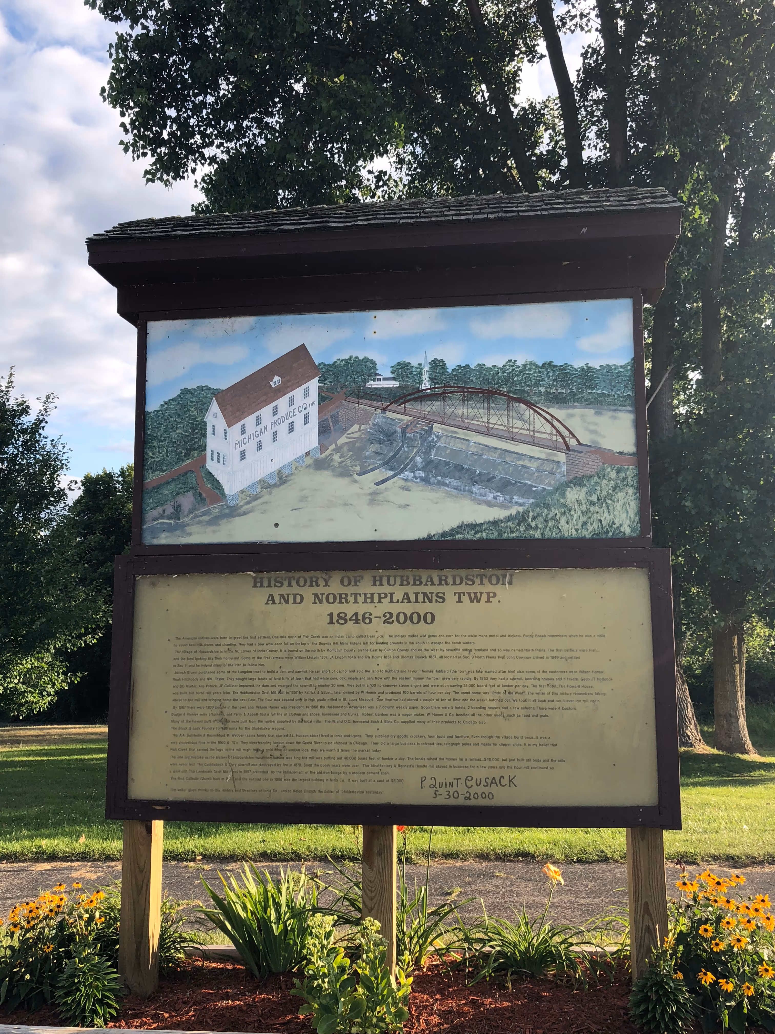 A picture of a sign at the Mill Pond Park showing the History of Hubbardston and Northplains Township.